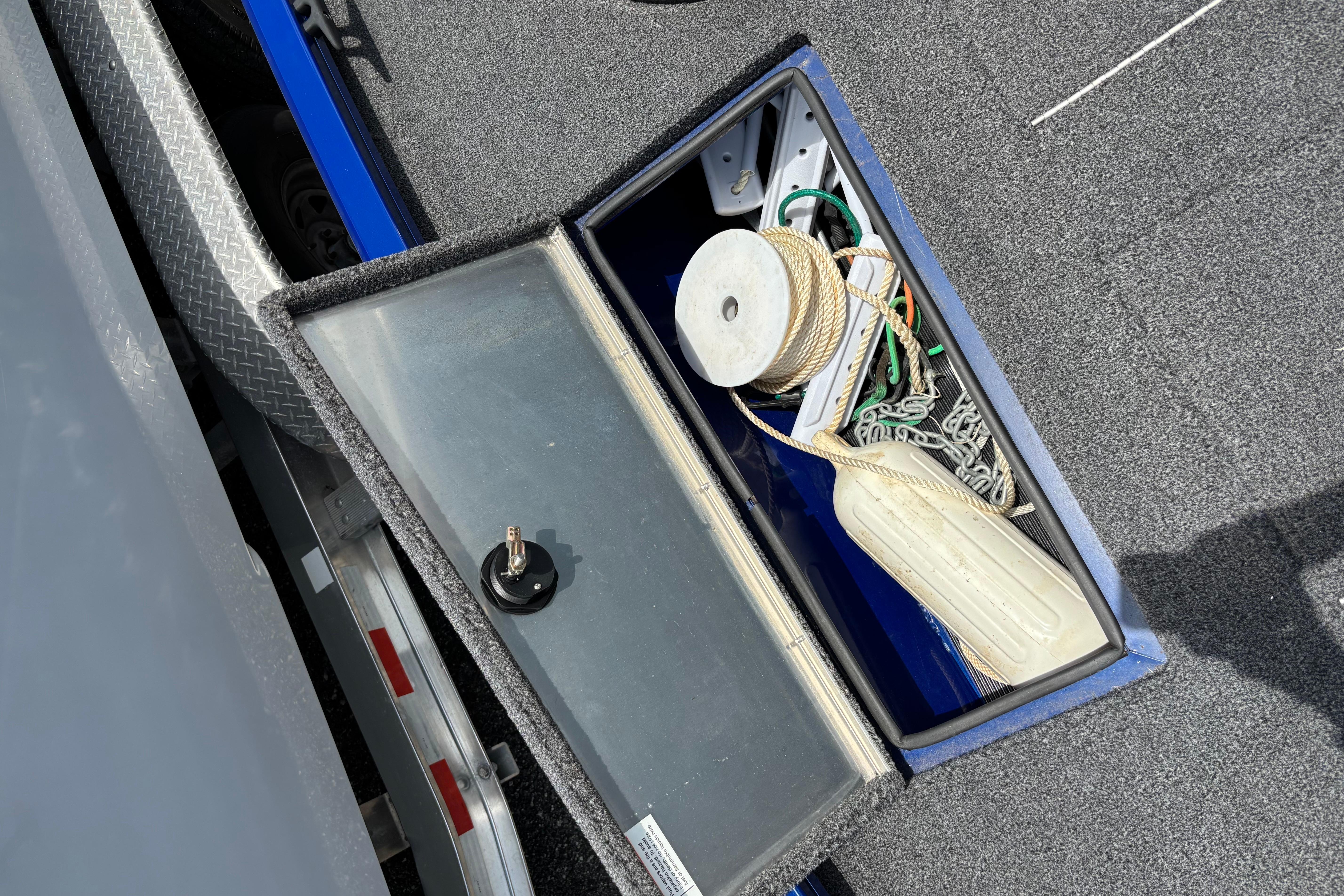 Storage compartment of a 2021 Lowe Stinger 175C boat with ropes and accessories.