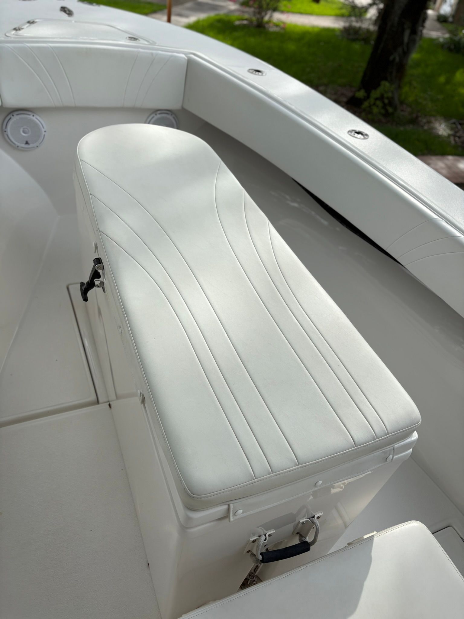 A white boat with a cushioned seat and clean design.