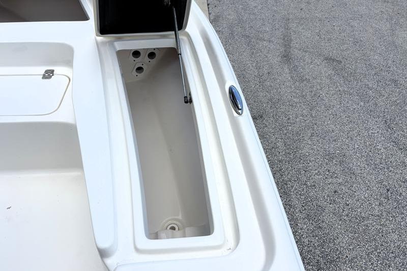 2025 Key West 210 Bay Reef boat storage compartment with open lid, showcasing interior space.