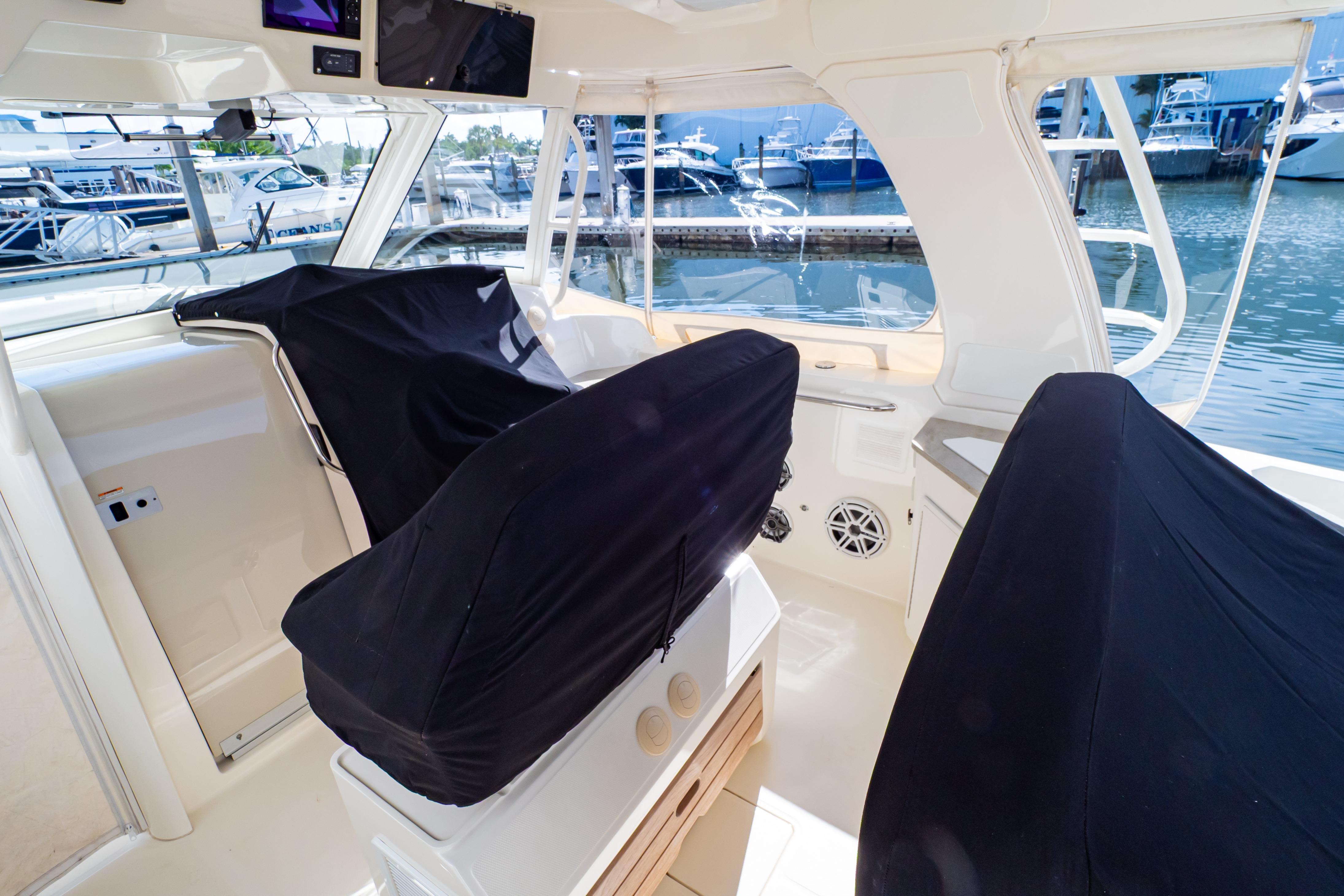 2019 Boston Whaler 350 Realm interior with covered seats, docked at marina.