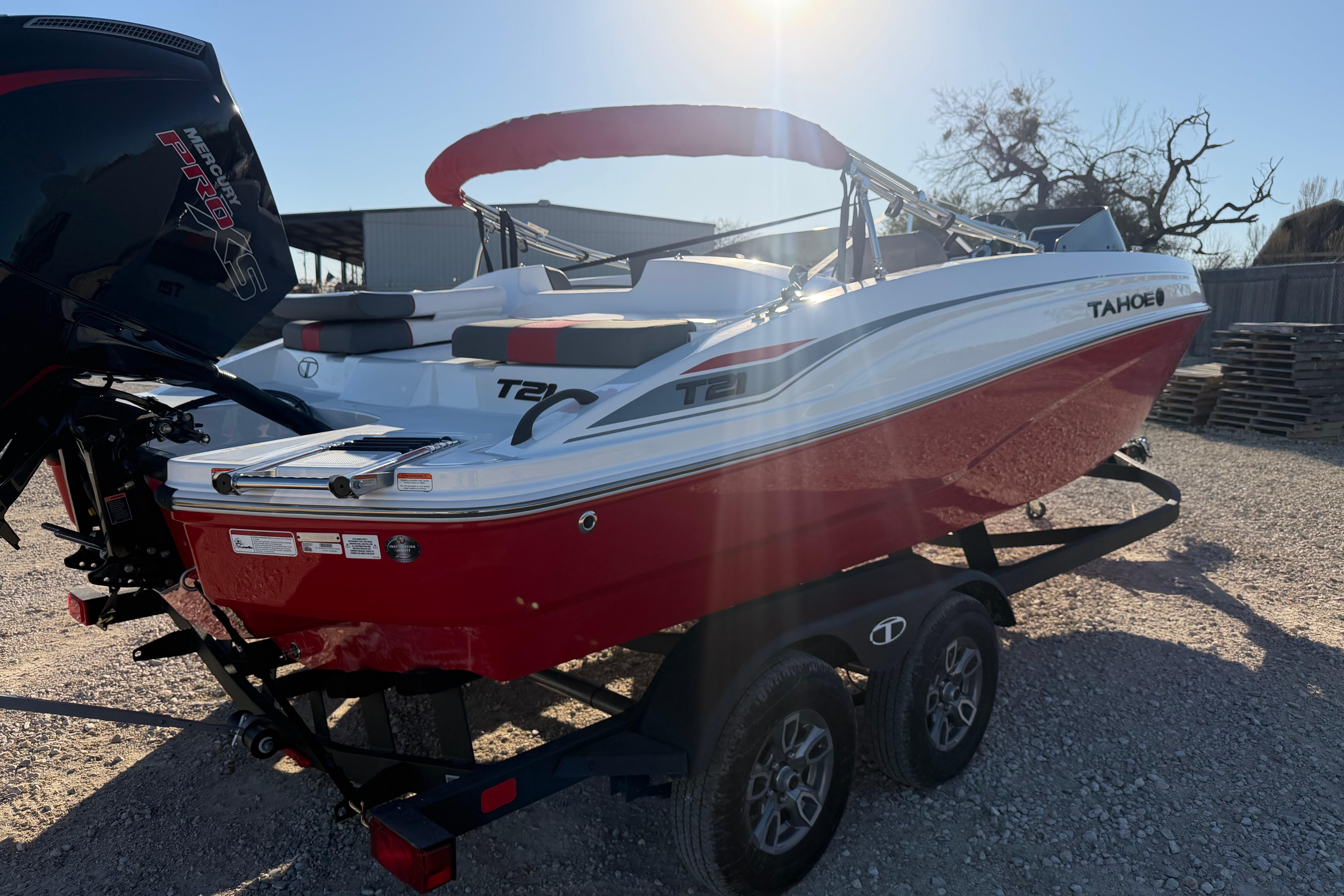 2026 Tahoe T21 boat with red and white design on a trailer in sunlight.