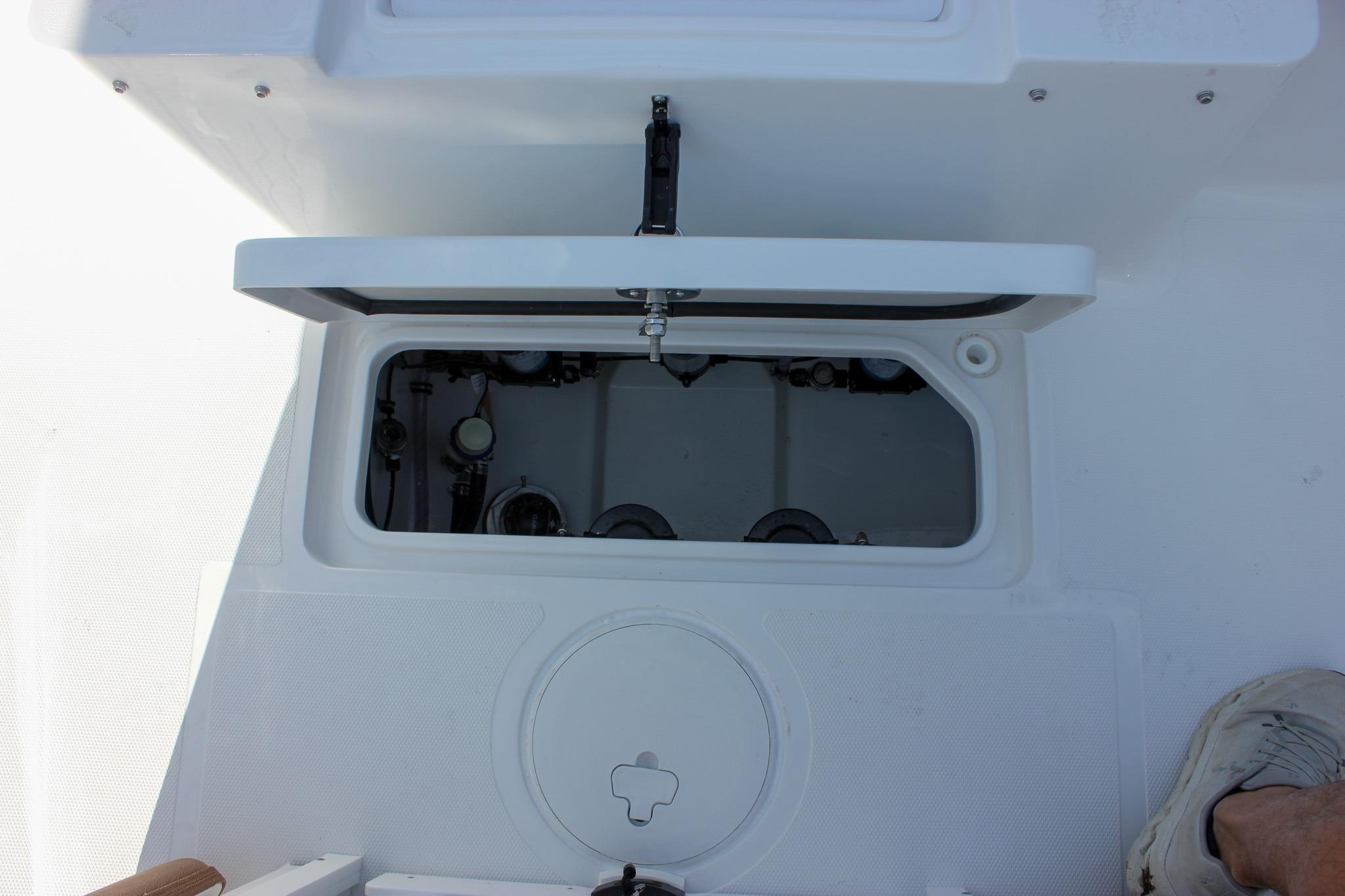 Open hatch on 2027 Sea Hunt Ultra 275 SE boat deck, revealing internal components.