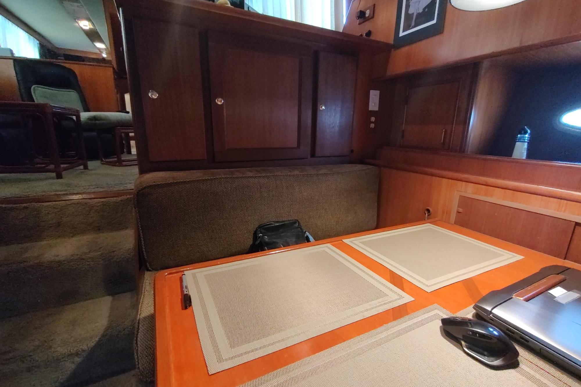 Interior of 1989 Hyatt Double Cabin Motoryacht with dining area and wooden cabinetry.