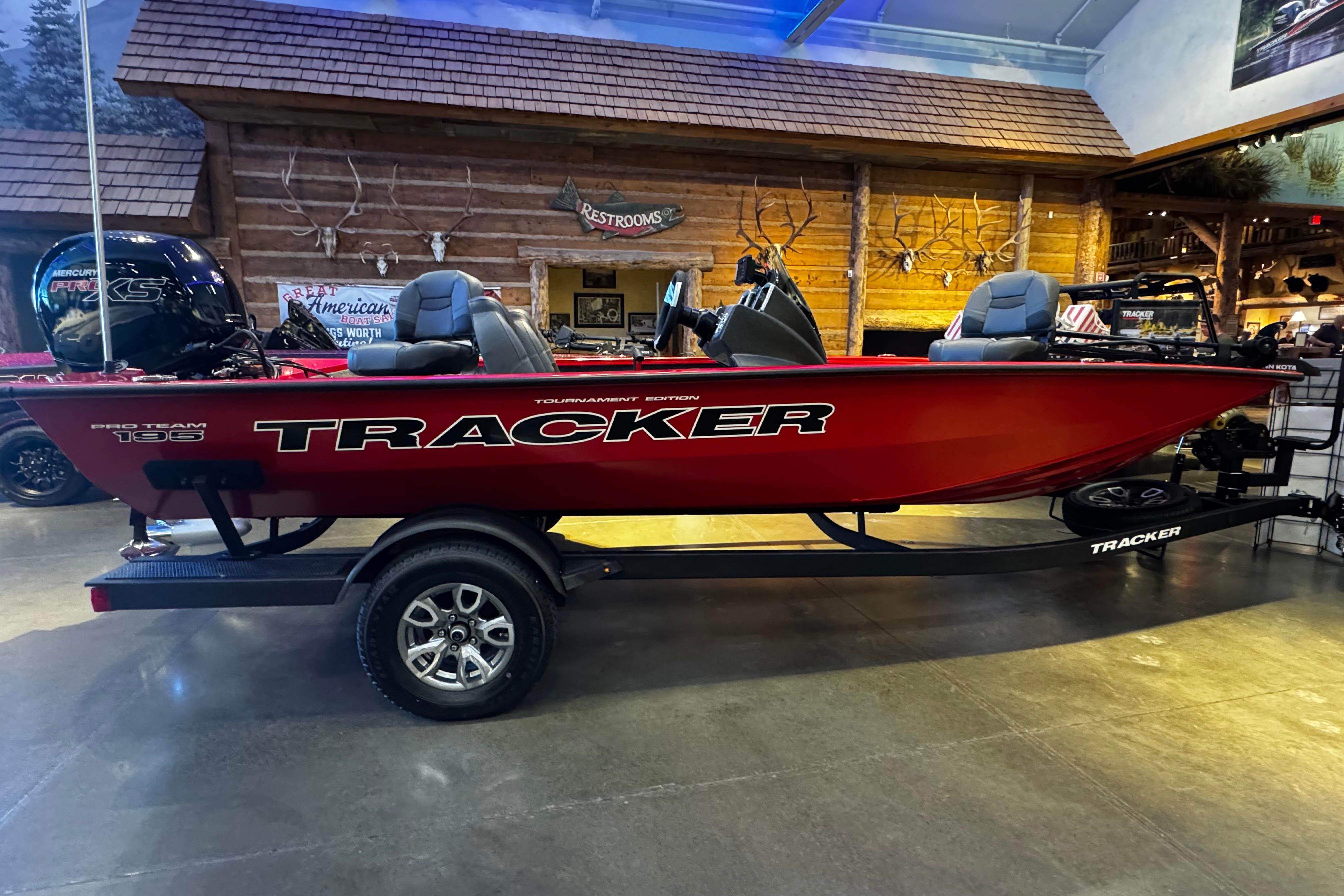 2026 Tracker Pro Team 195 boat displayed indoors, featuring a vibrant red exterior.