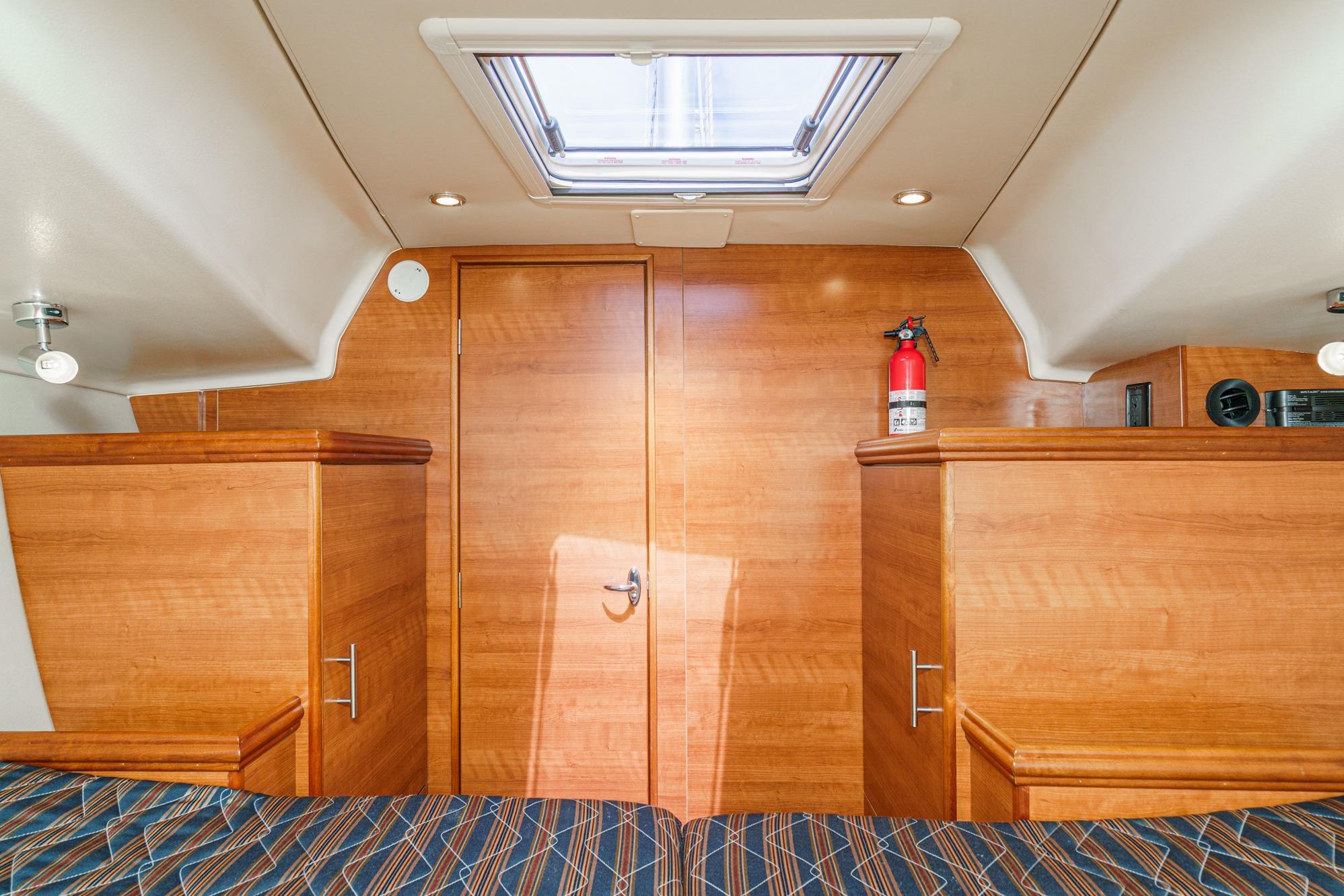 Interior cabin of 2015 Hunter 33 yacht with wood finish and fire extinguisher.