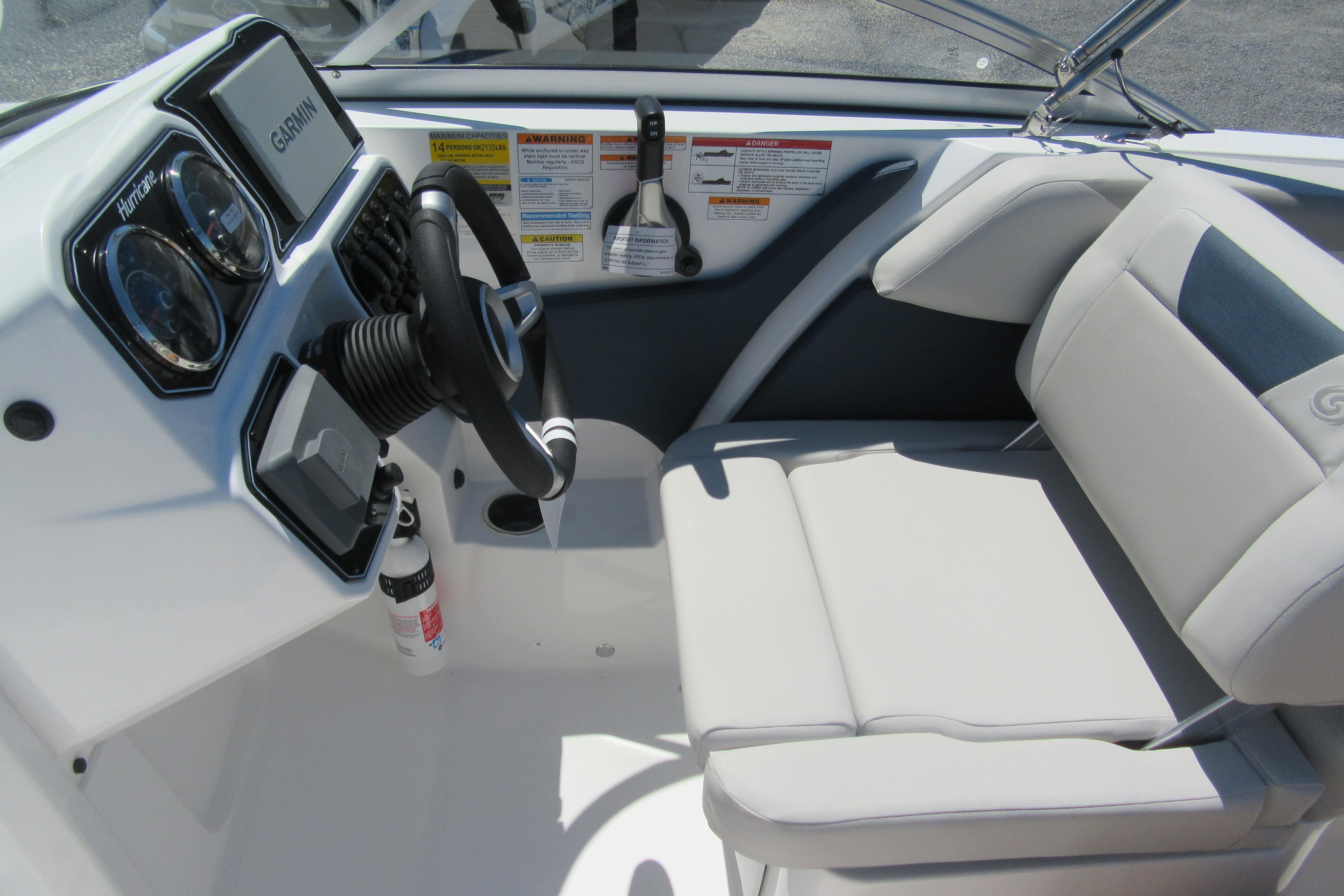 2027 Hurricane SunDeck 2050 OB boat cockpit with steering wheel and comfortable seating.