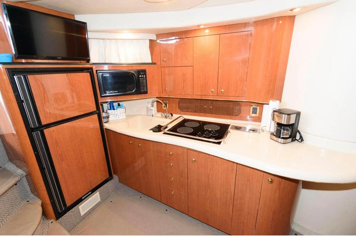 Luxurious 1999 Sea Ray Sundancer 400 yacht kitchen with modern appliances and elegant wood cabinetry.