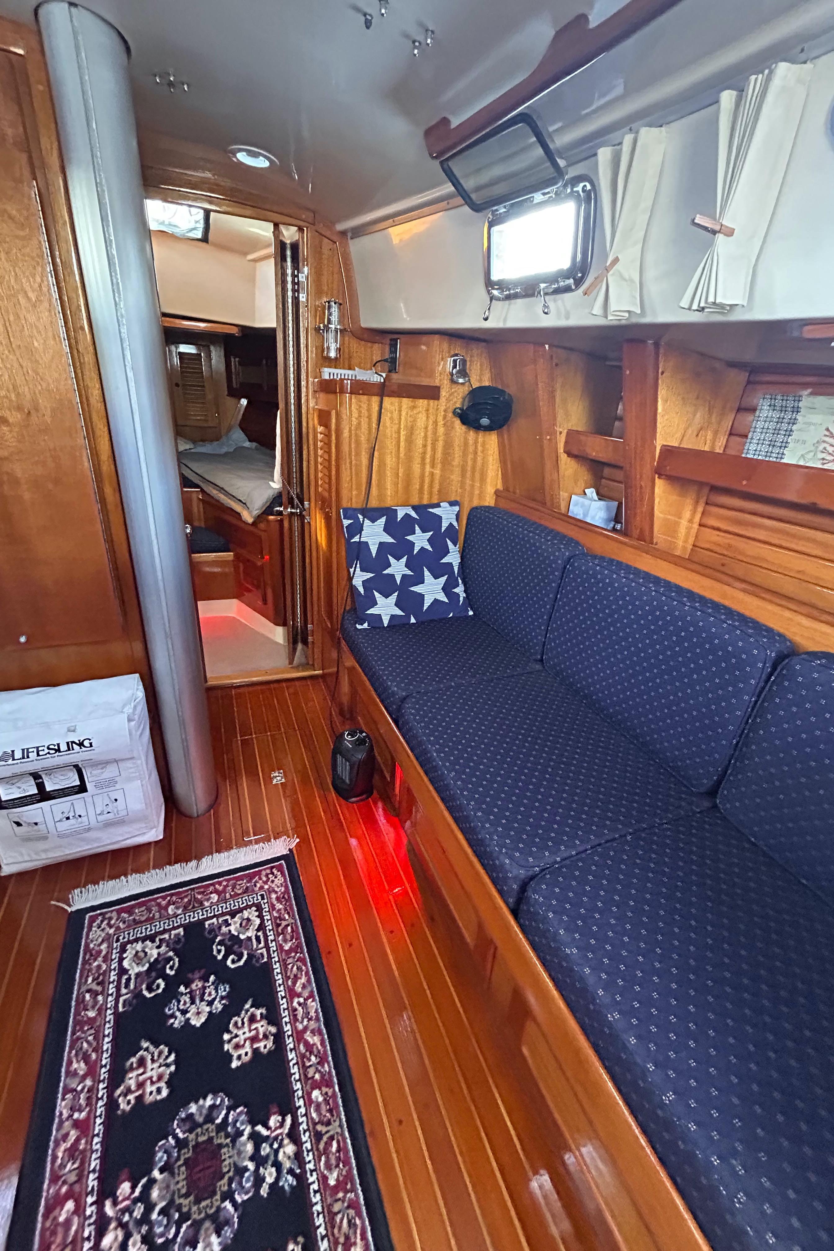 1980 Bristol 35.5 yacht interior with blue seating, wooden flooring, and nautical decor.