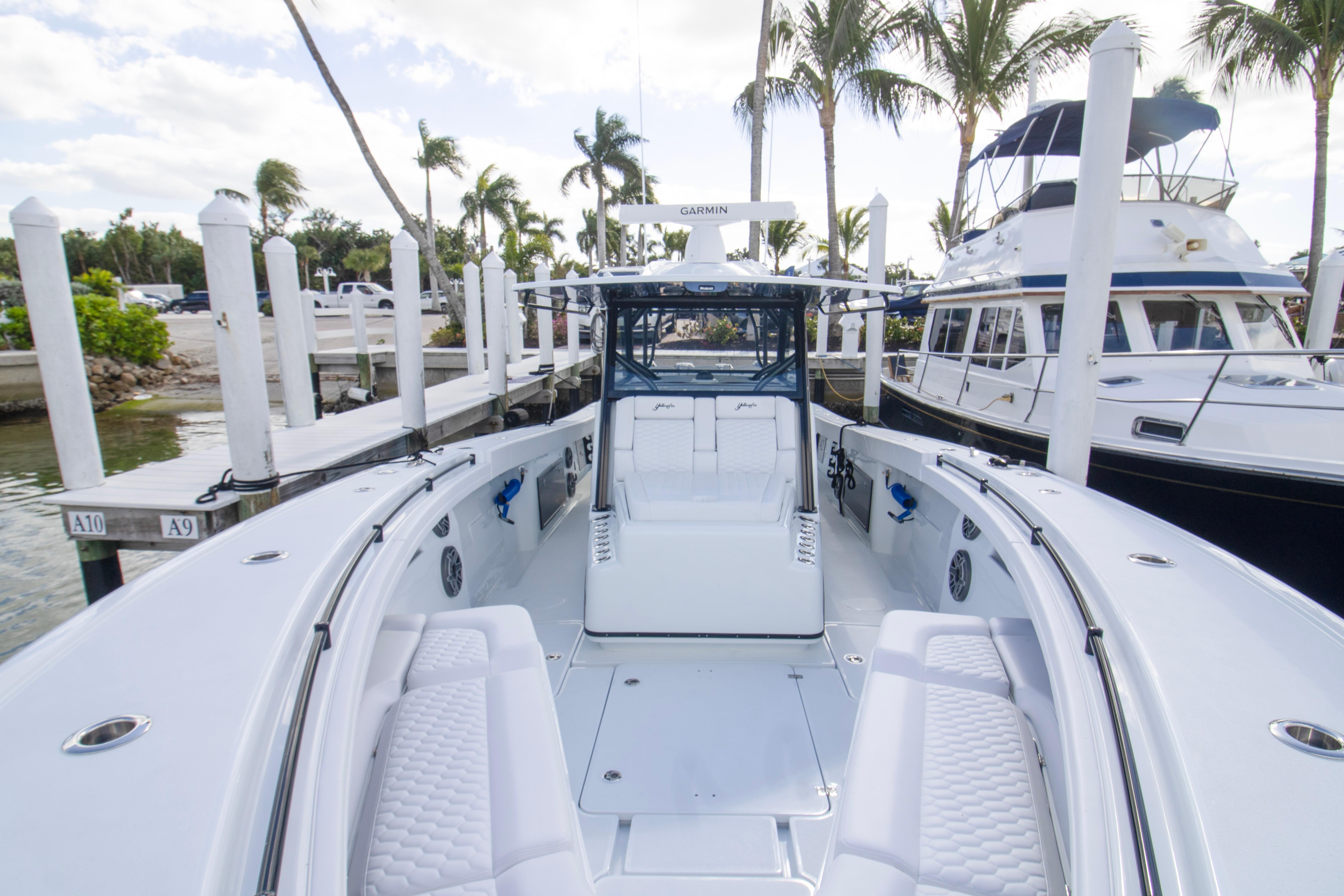 2026 Yellowfin 42 Offshore boat docked at marina with palm trees.