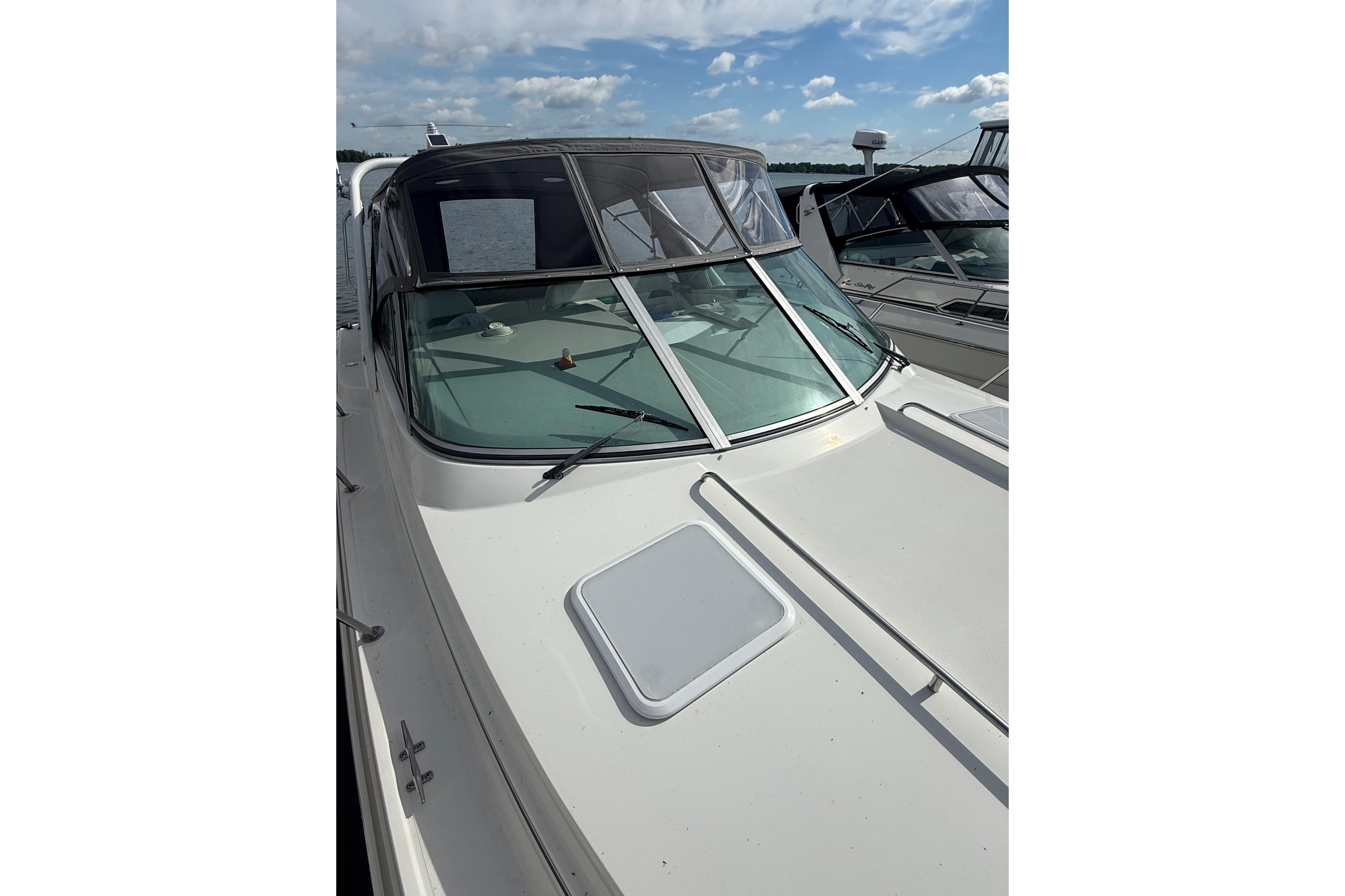 1999 Formula 34 Performance Cruiser boat docked under a partly cloudy sky.