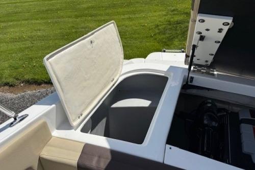 2017 Rinker QX21 BR boat storage compartment open, showcasing spacious interior.