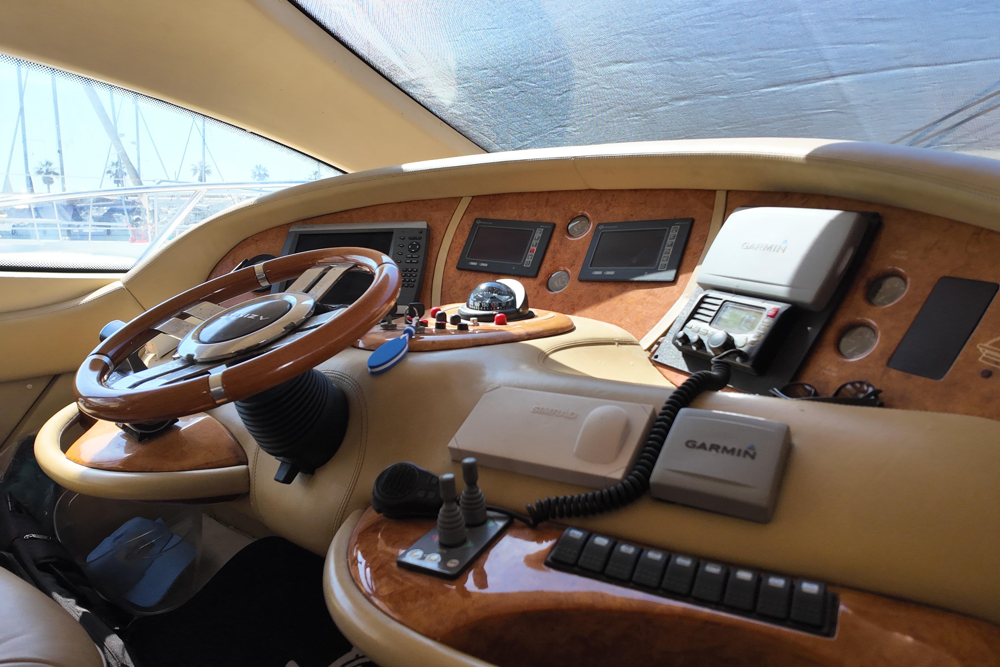 Interior helm of 2006 Azimut 68E yacht with steering wheel and navigation equipment.