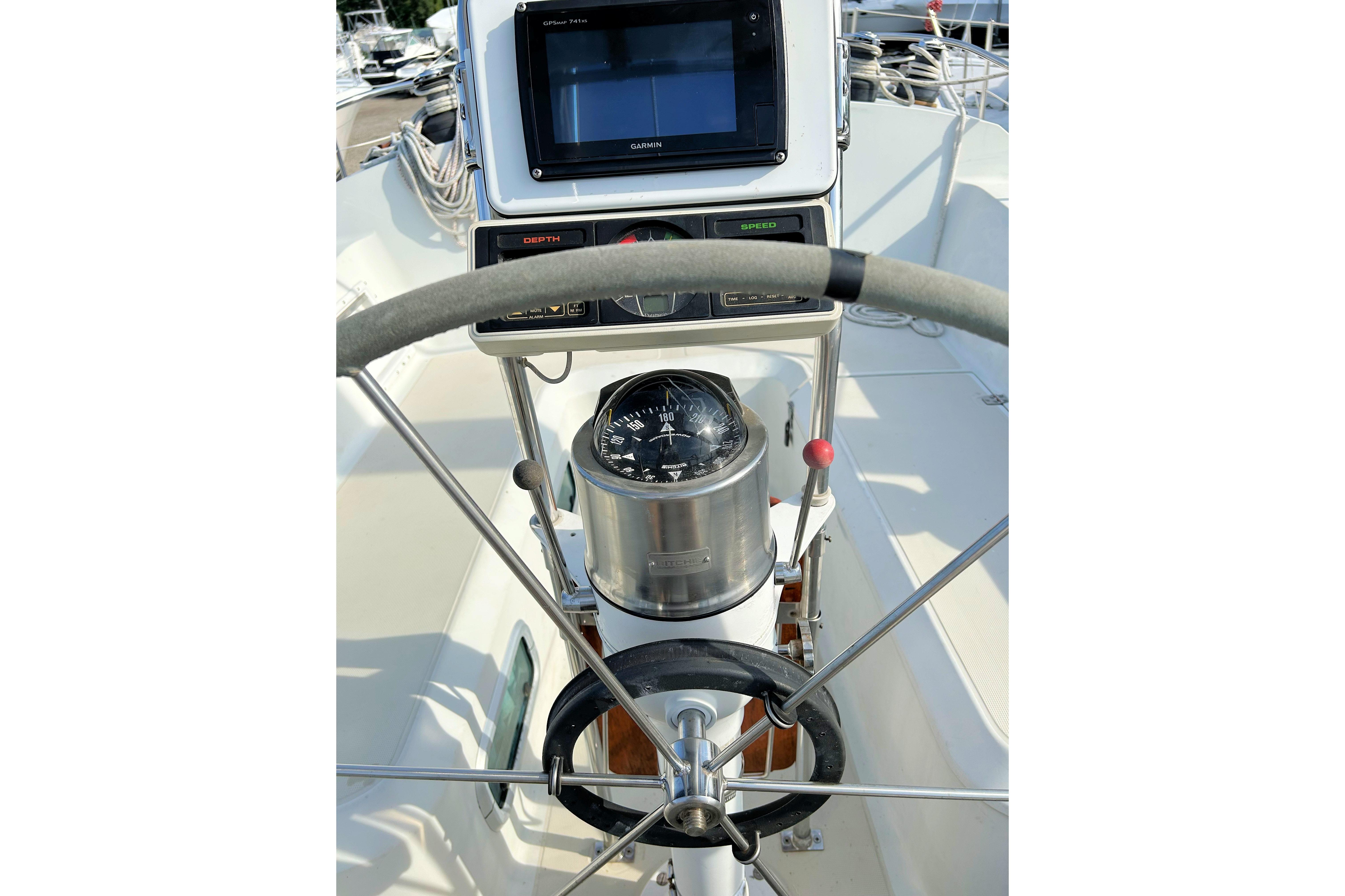 Cockpit view of 1987 Ericson 38-200 sailboat with steering wheel and navigation instruments.
