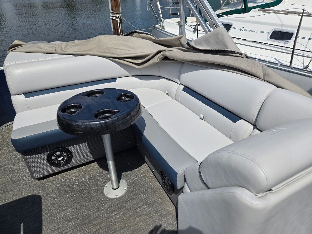 Interior of a Godfrey Sweetwater 2186C pontoon boat with gray seating and a table.