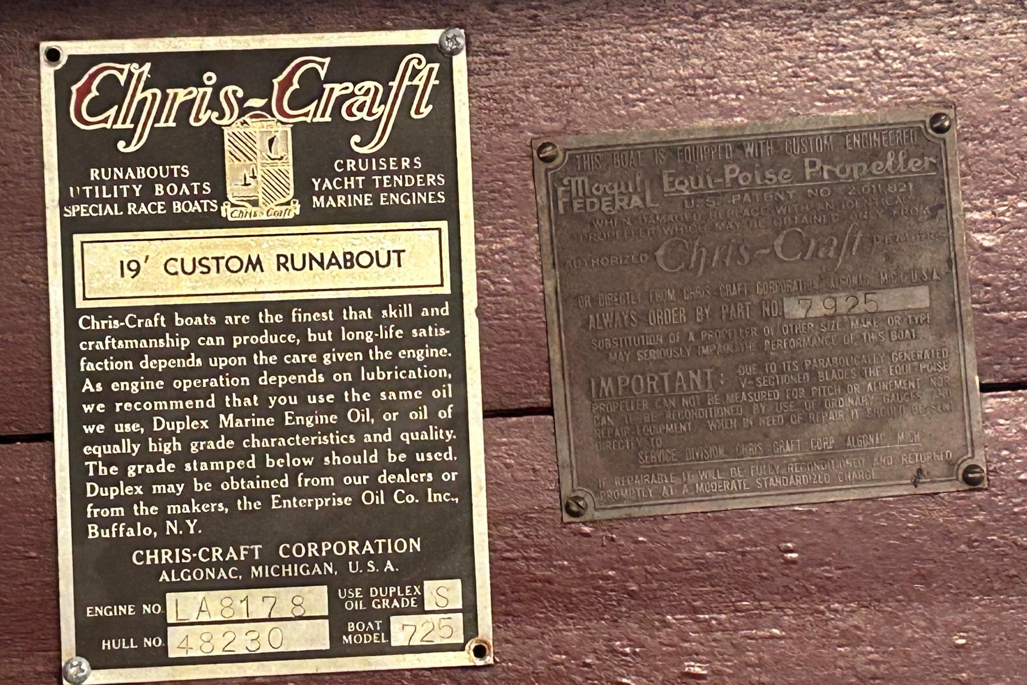 1937 Chris-Craft 18 Runabout engine and propeller information plates on wooden surface.