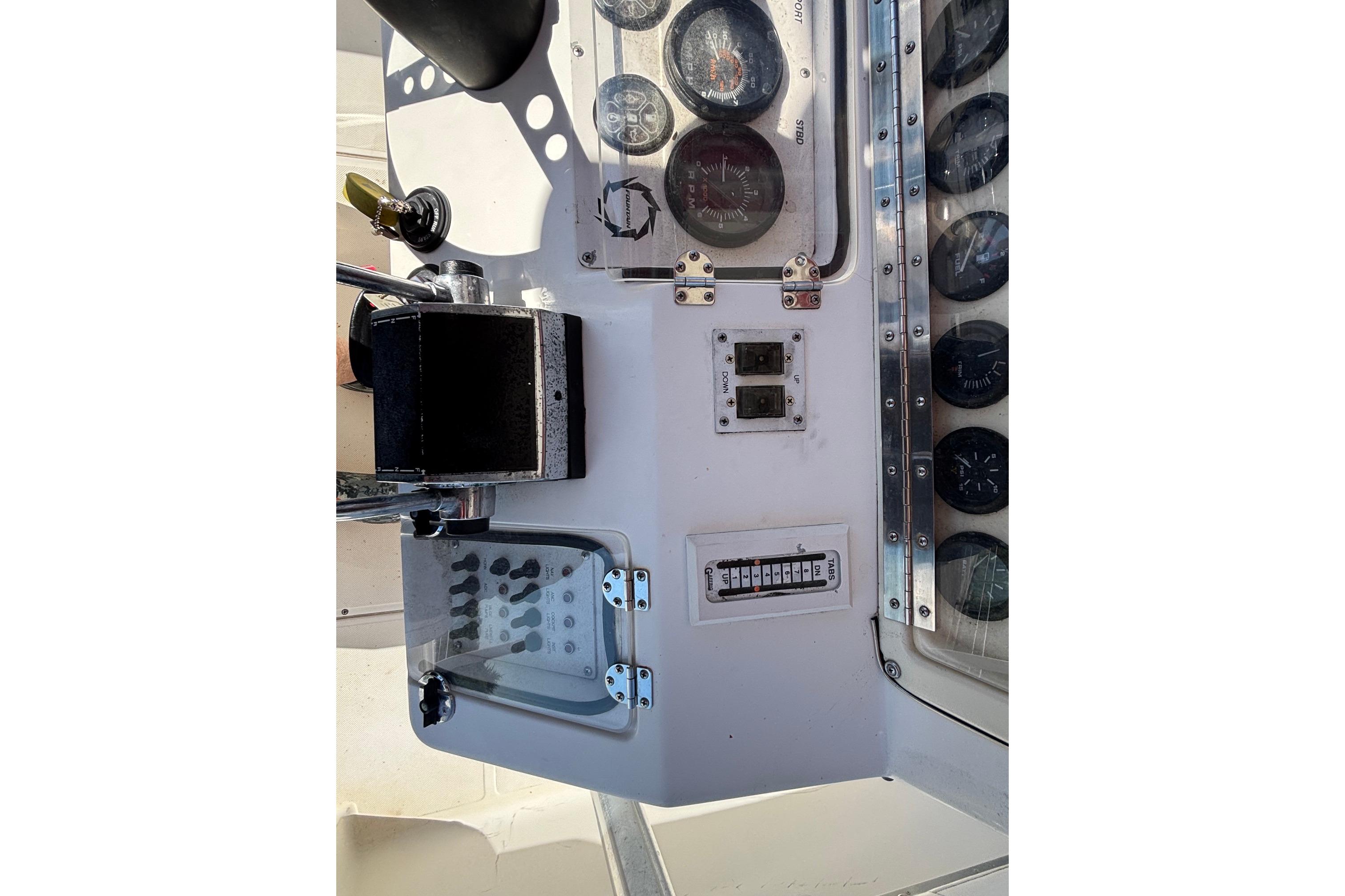 Control panel of a 2000 Fountain 29 Sportfish CC boat with gauges and switches.