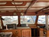 Interior of a 1977 Davis 42' boat with wooden cabinetry and nautical decor.