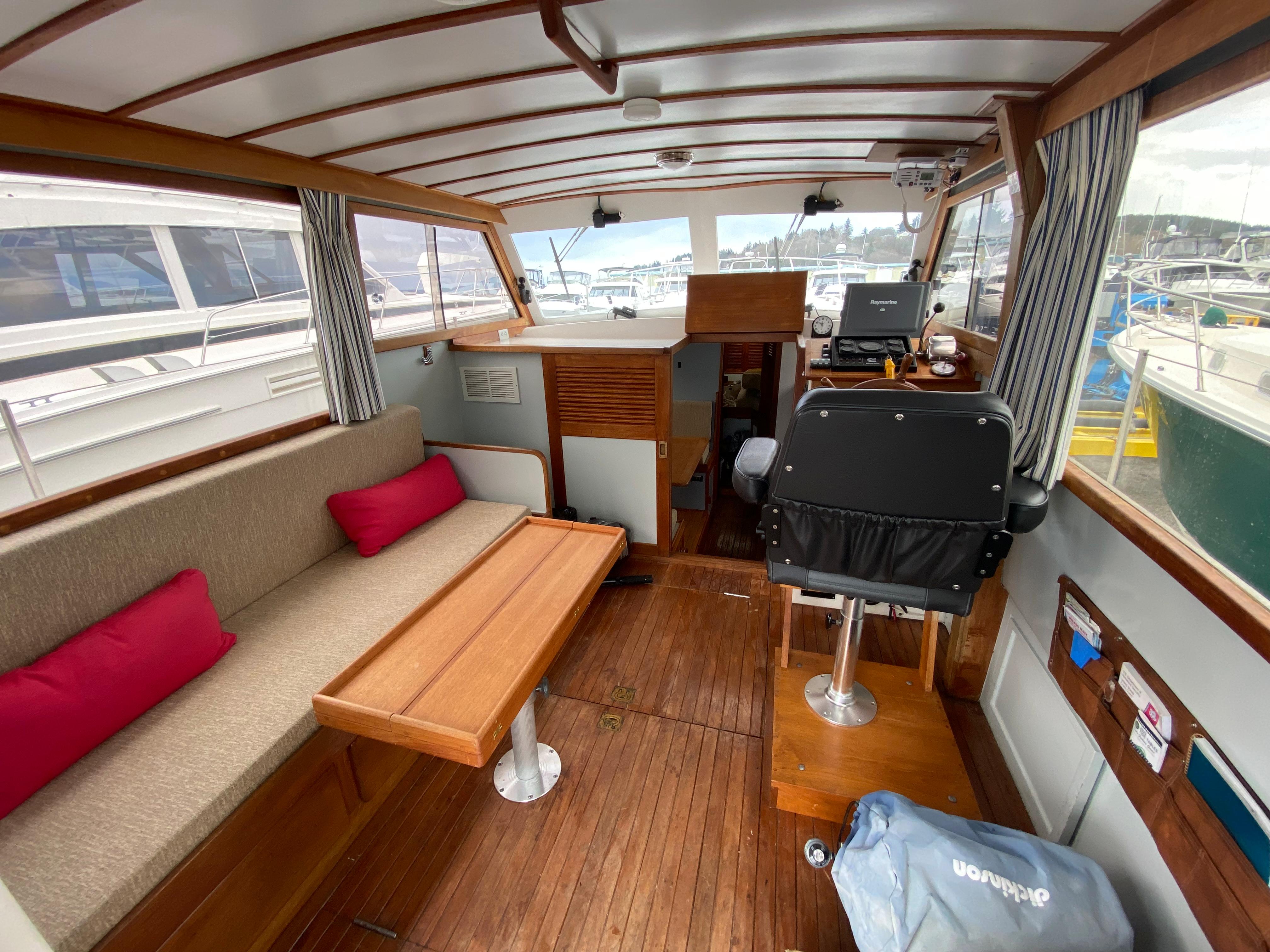 1981 Rough Water 37 Sedan boat interior with wooden flooring, seating area, and helm station.
