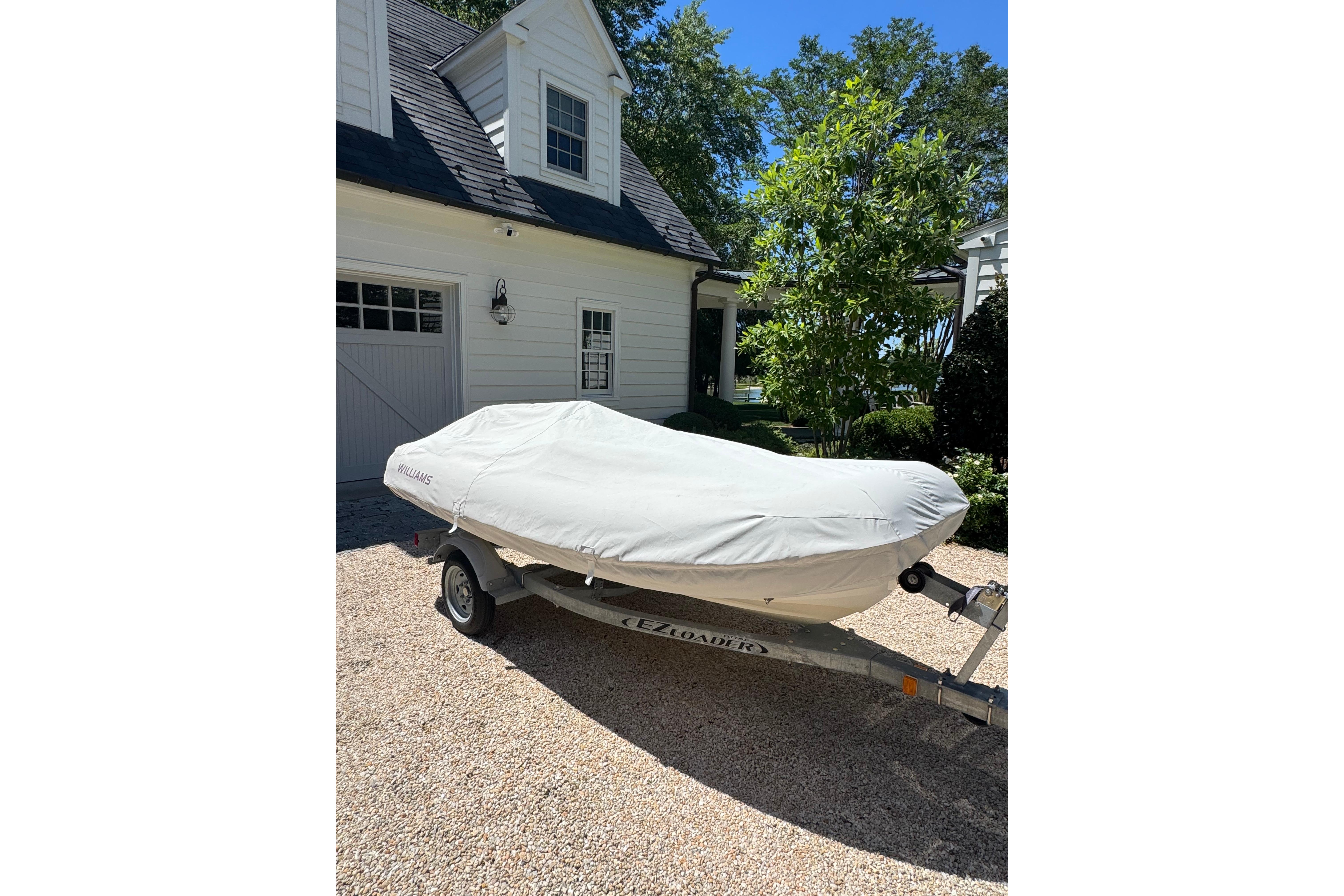 2017 Williams Jet Tenders Turbojet 325 covered on trailer, parked in driveway.