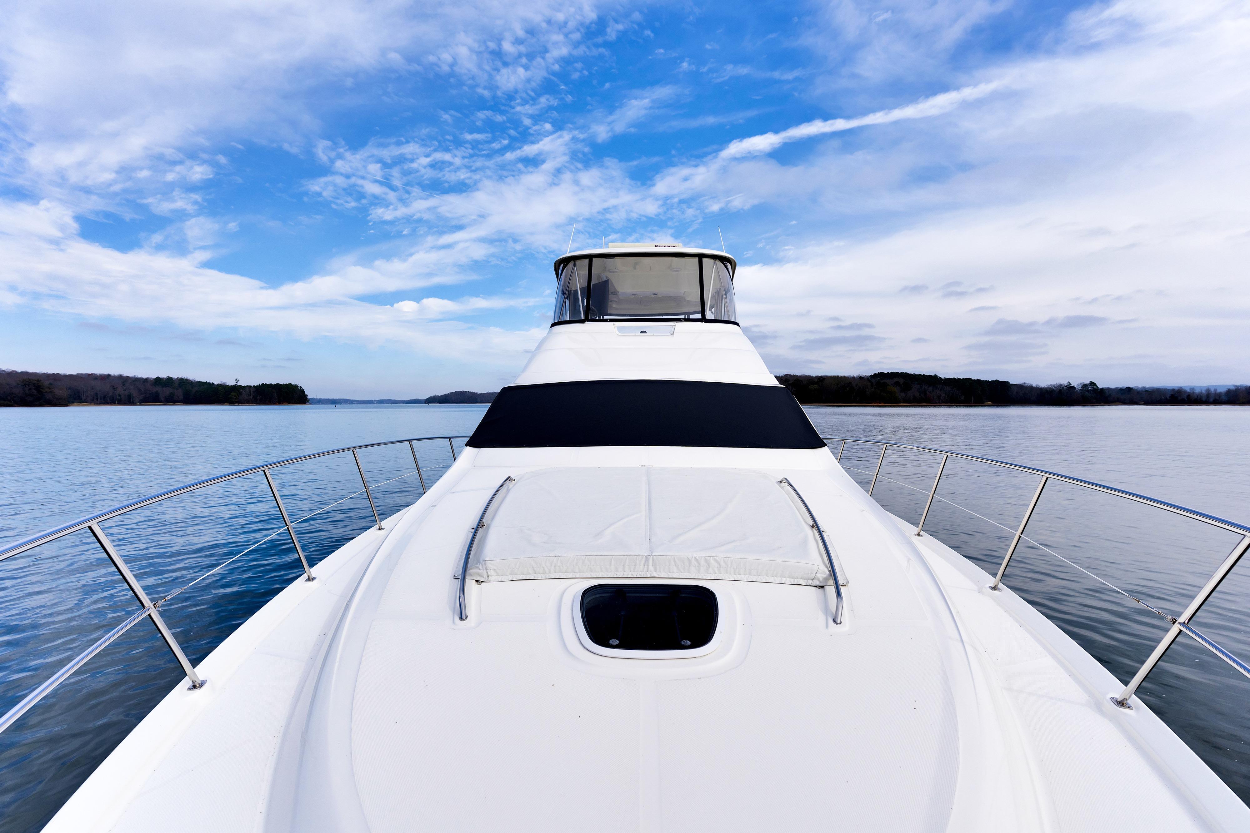 2006 Sea Ray 58 Sedan Bridge yacht on calm water under blue sky.