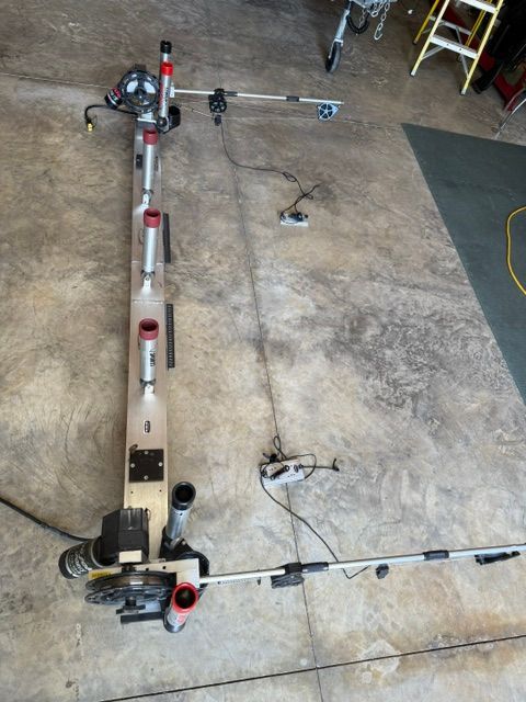 A fishing rod holder and accessories on a concrete floor, ready for installation on a boat.