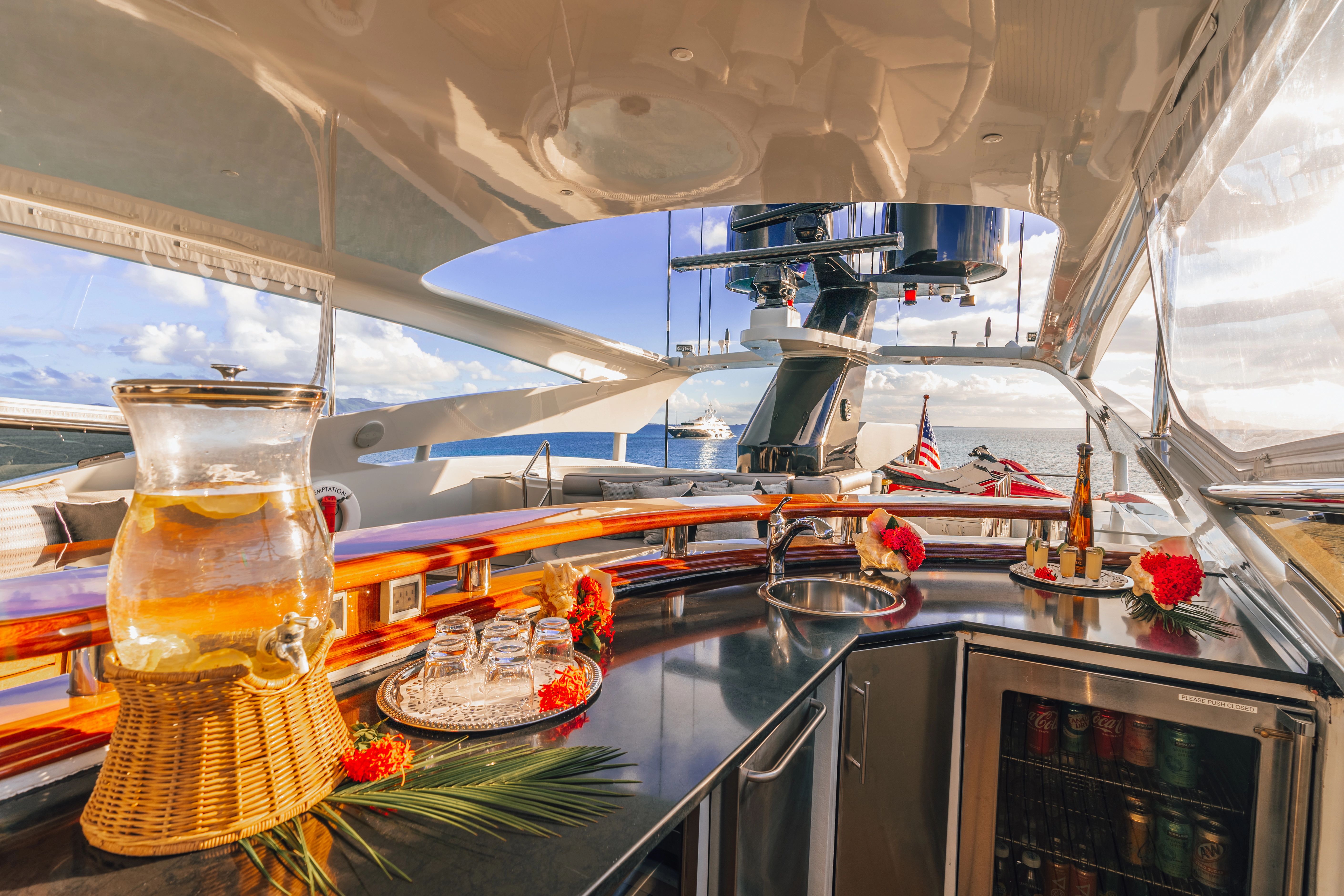 Luxurious yacht bar with drinks and flowers, surrounded by ocean views.