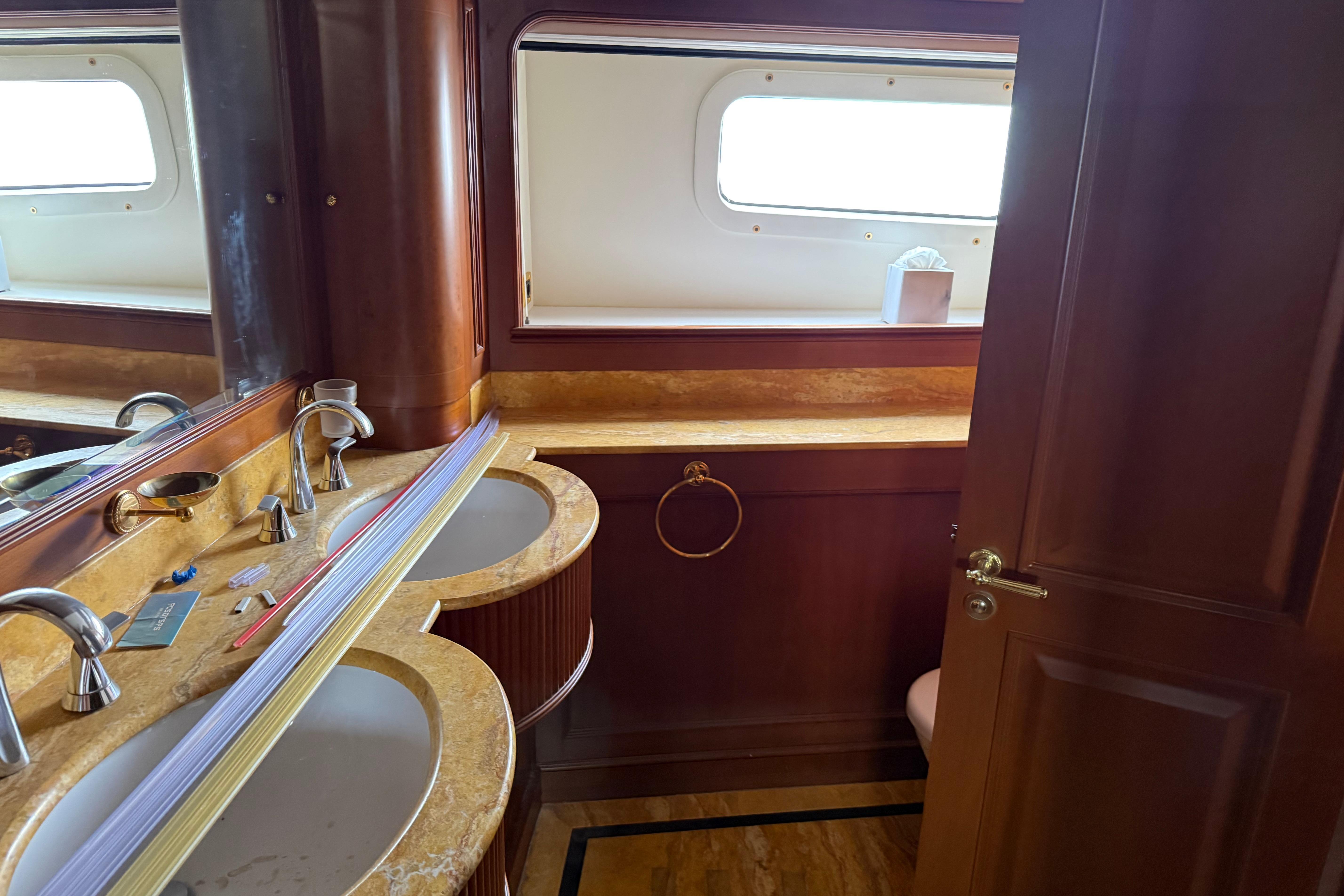 Luxurious bathroom interior of 2003 Benetti Classic 115 yacht with dual sinks and wooden accents.