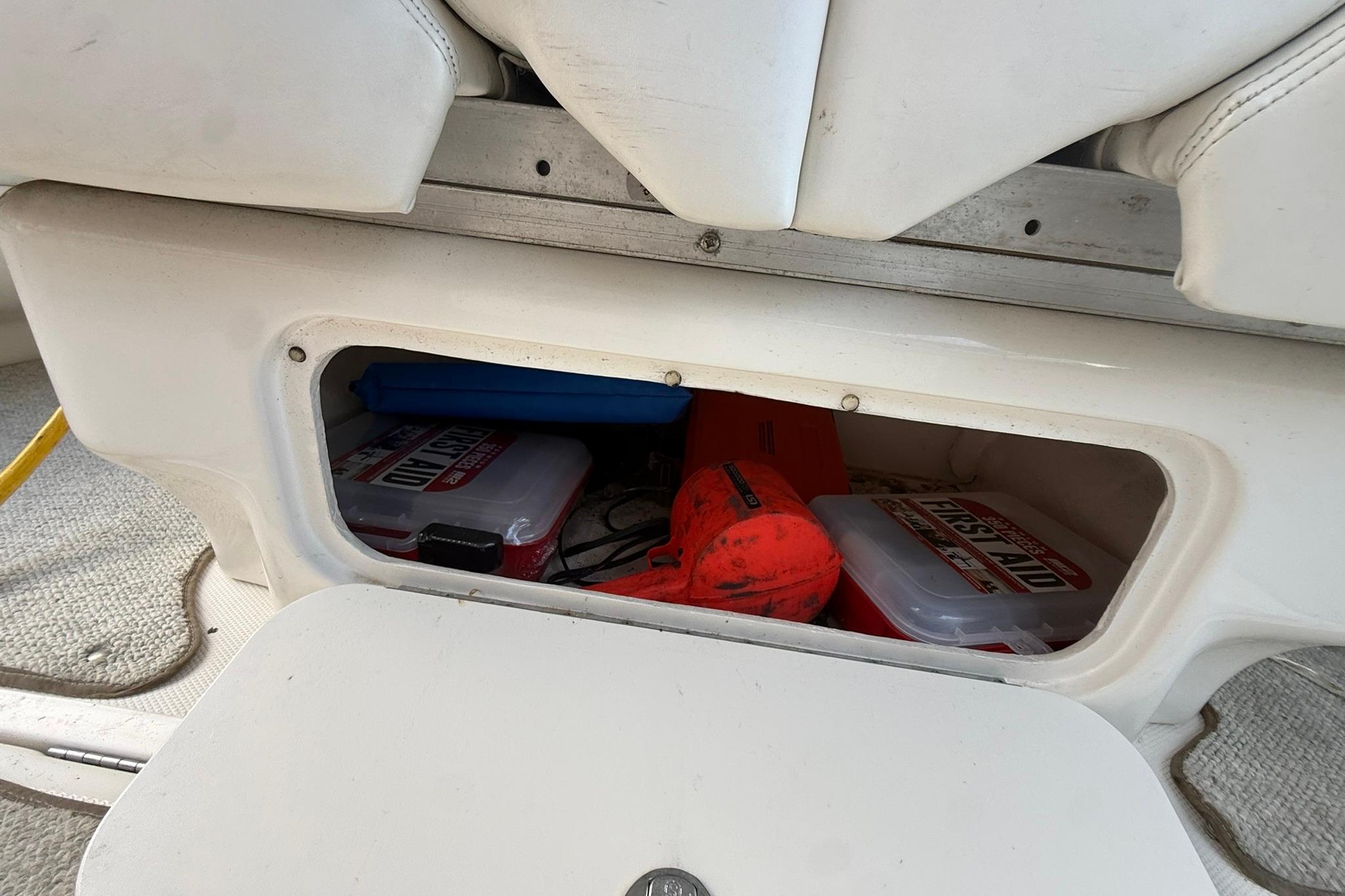 Storage compartment on a 2005 Sea Ray 290 SLX boat with safety equipment.