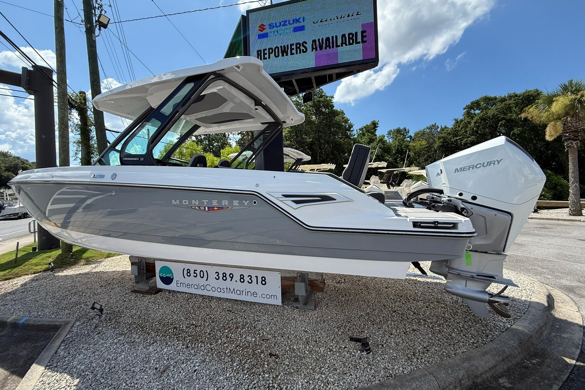 2027 Monterey Elite 30 OB boat displayed outdoors with Mercury engine.