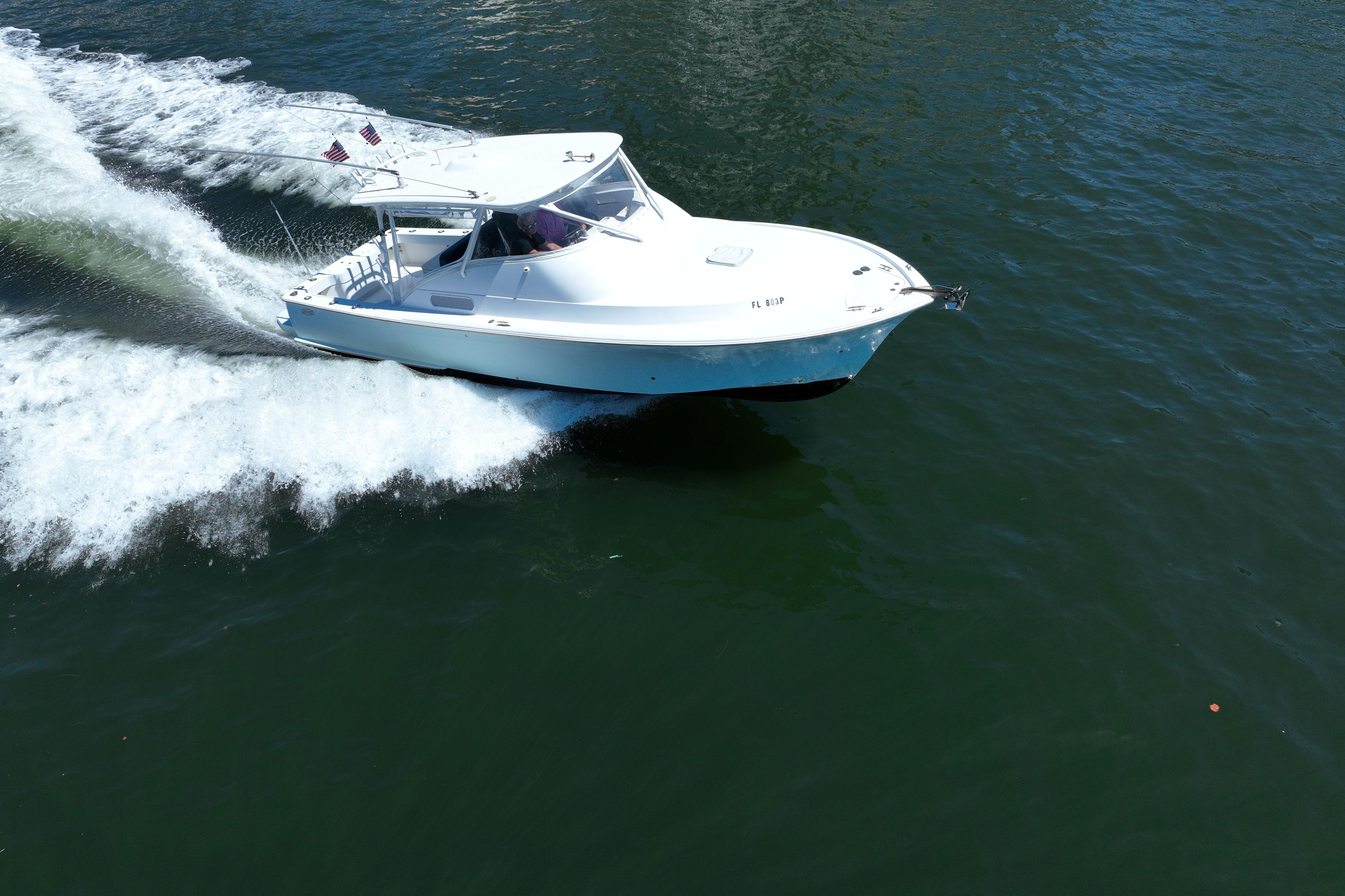 2012 Custom Carolina 34 boat cruising on open water, creating a wake.