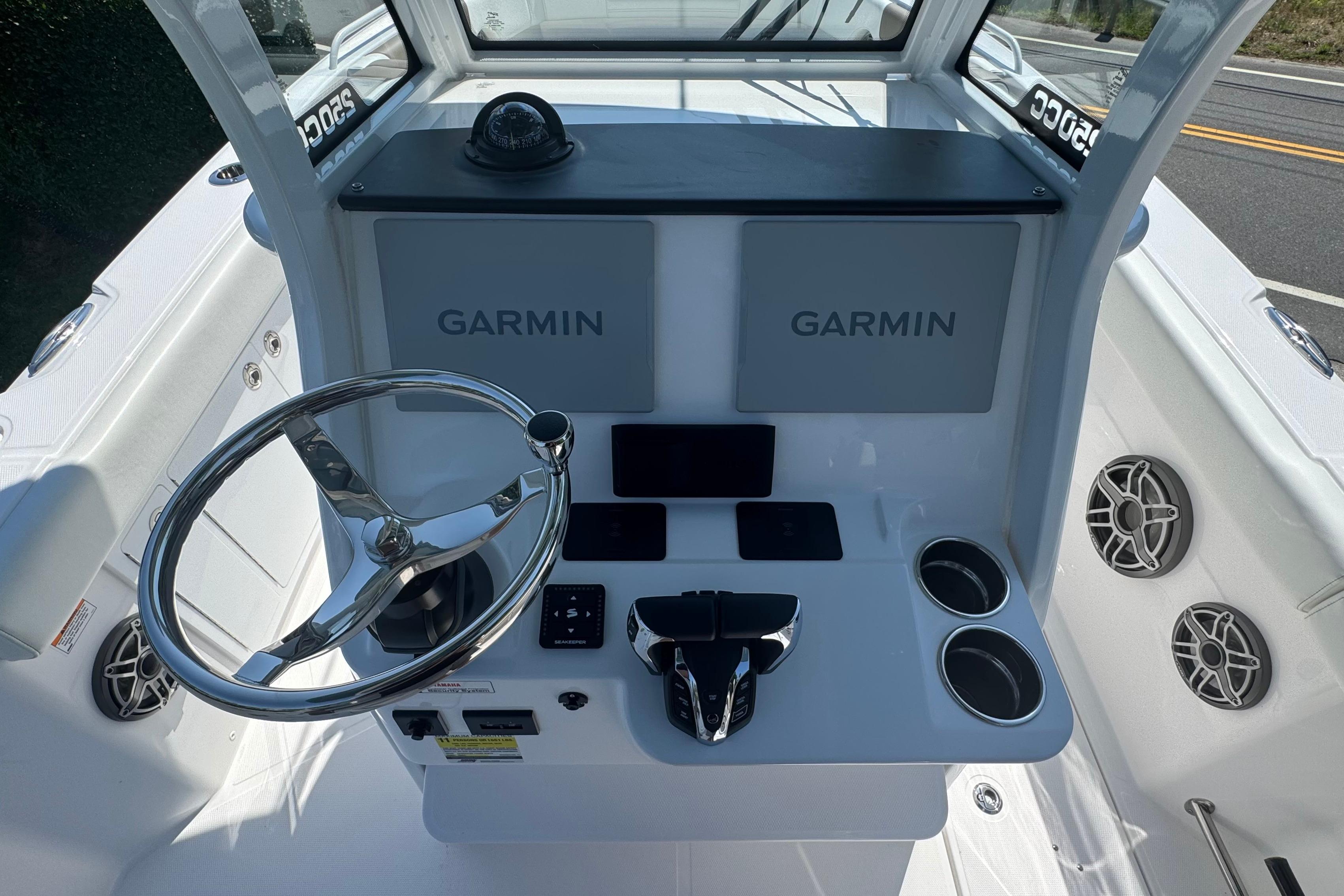 2026 Edgewater 250CC boat helm with Garmin displays and chrome steering wheel.