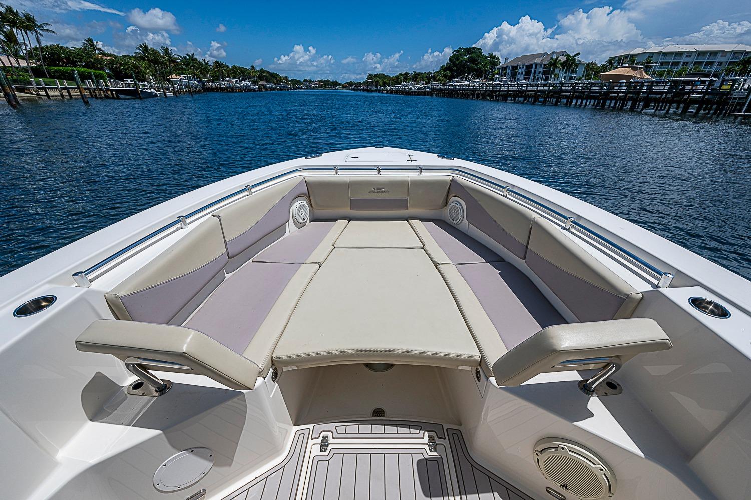 2019 Cobia 320 Center Console boat with spacious seating on calm waterway.