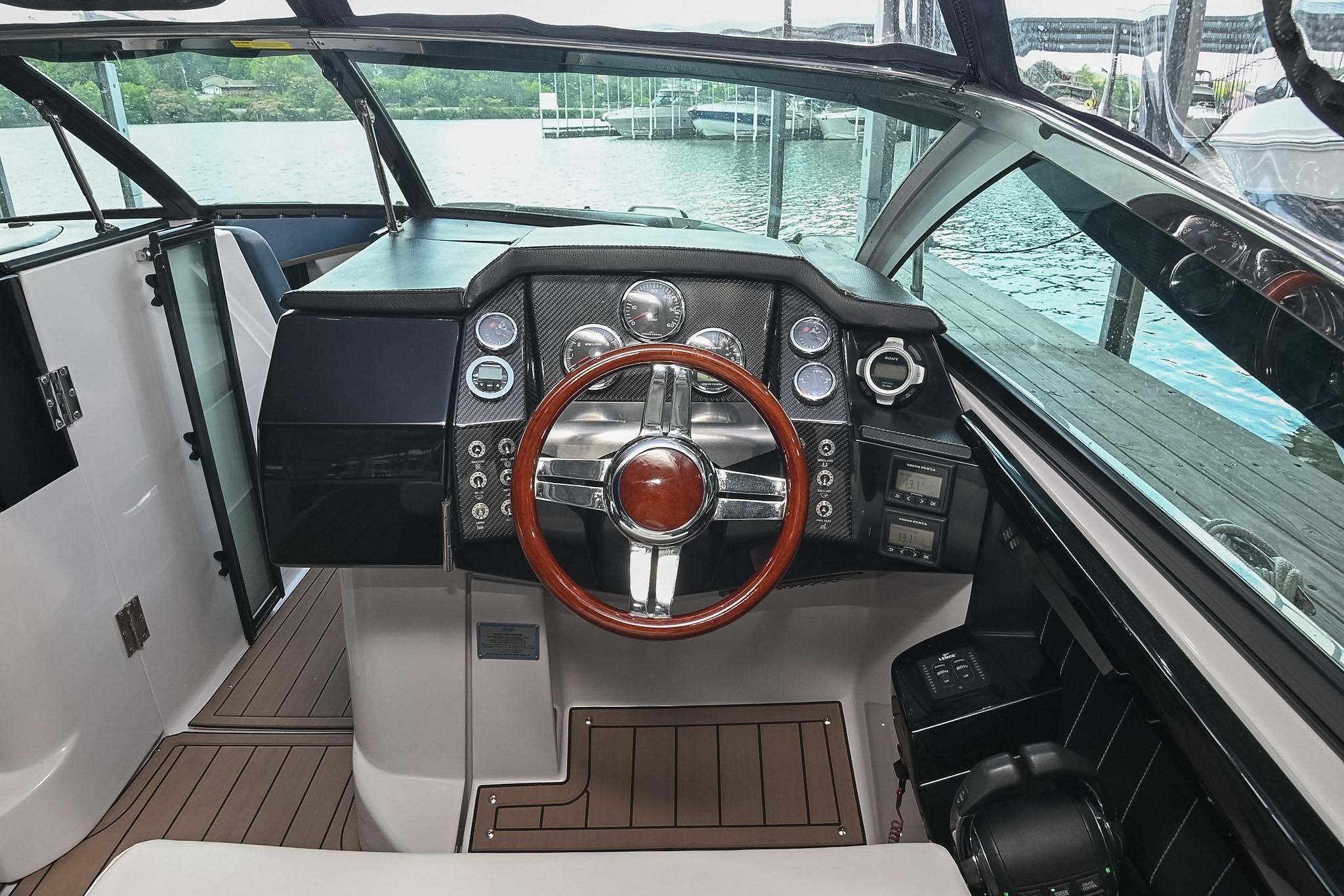 2014 Four Winns H290 boat cockpit with sleek dashboard and wooden steering wheel.
