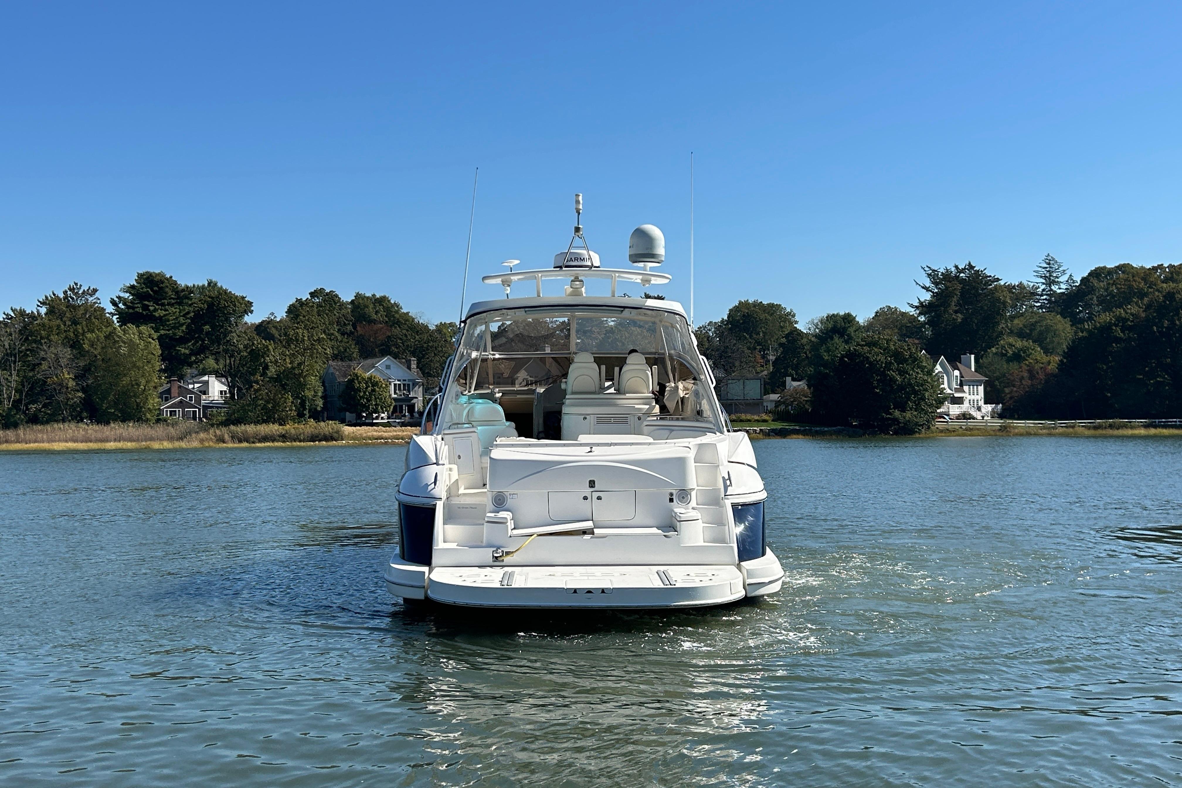 2003 Cruisers Yachts 540 Express on calm water, surrounded by trees and houses.