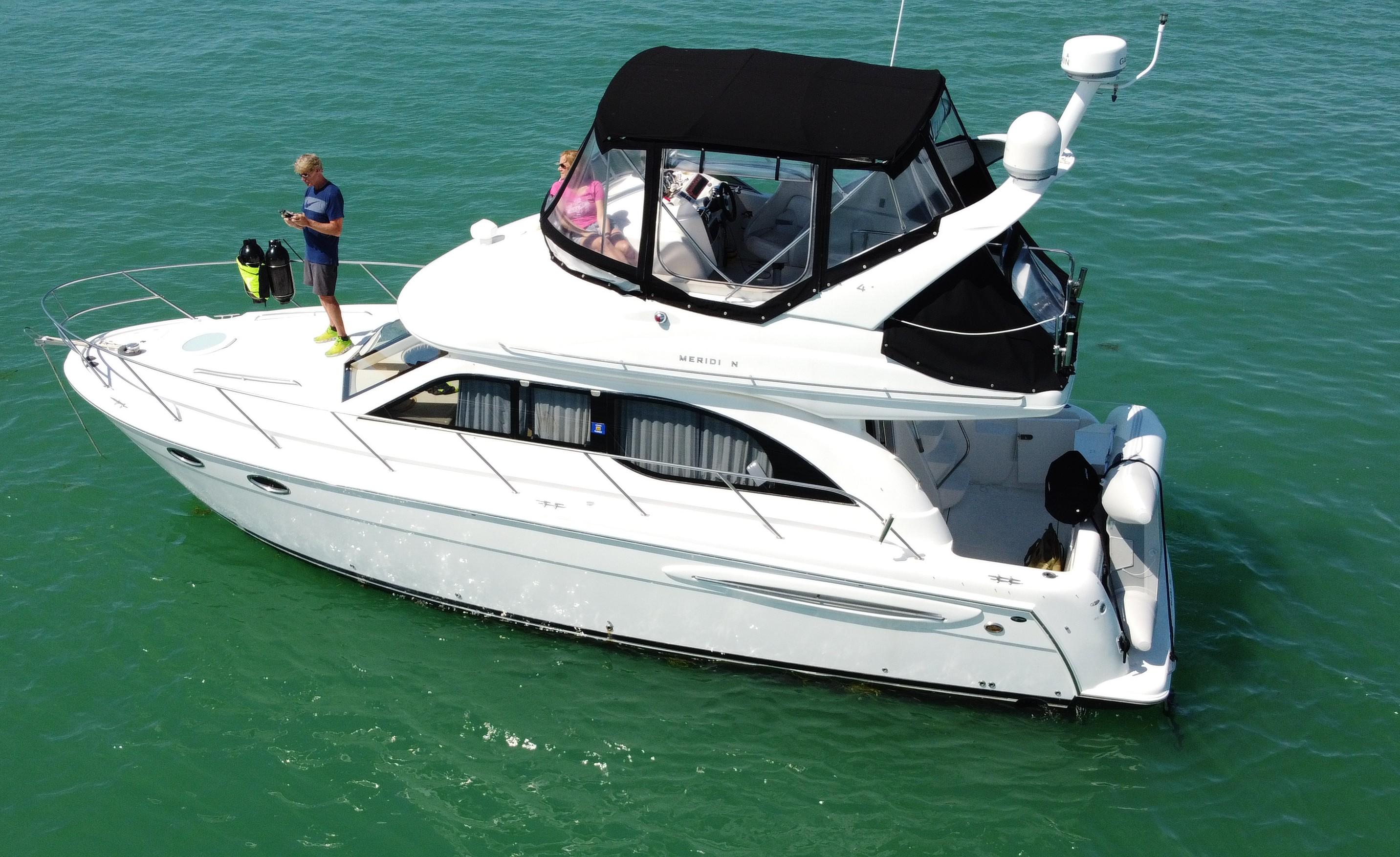 2004 Meridian 341 Sedan yacht cruising on clear turquoise waters.