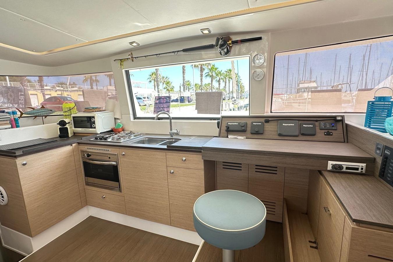 Interior of 2016 Bali 4.0 catamaran kitchen with modern appliances and navigation controls.