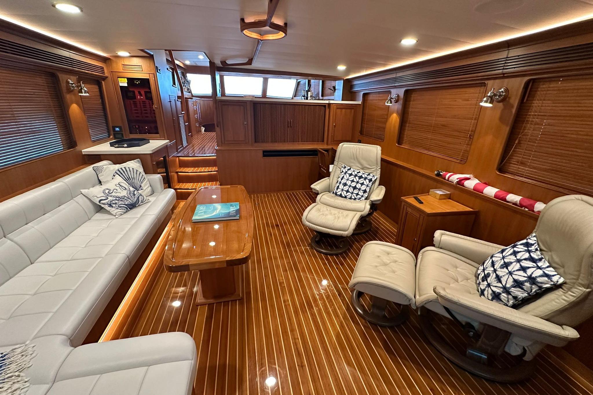 Luxurious interior of 2023 Marlow Explorer 66E-CB yacht with elegant seating and wooden finishes.
