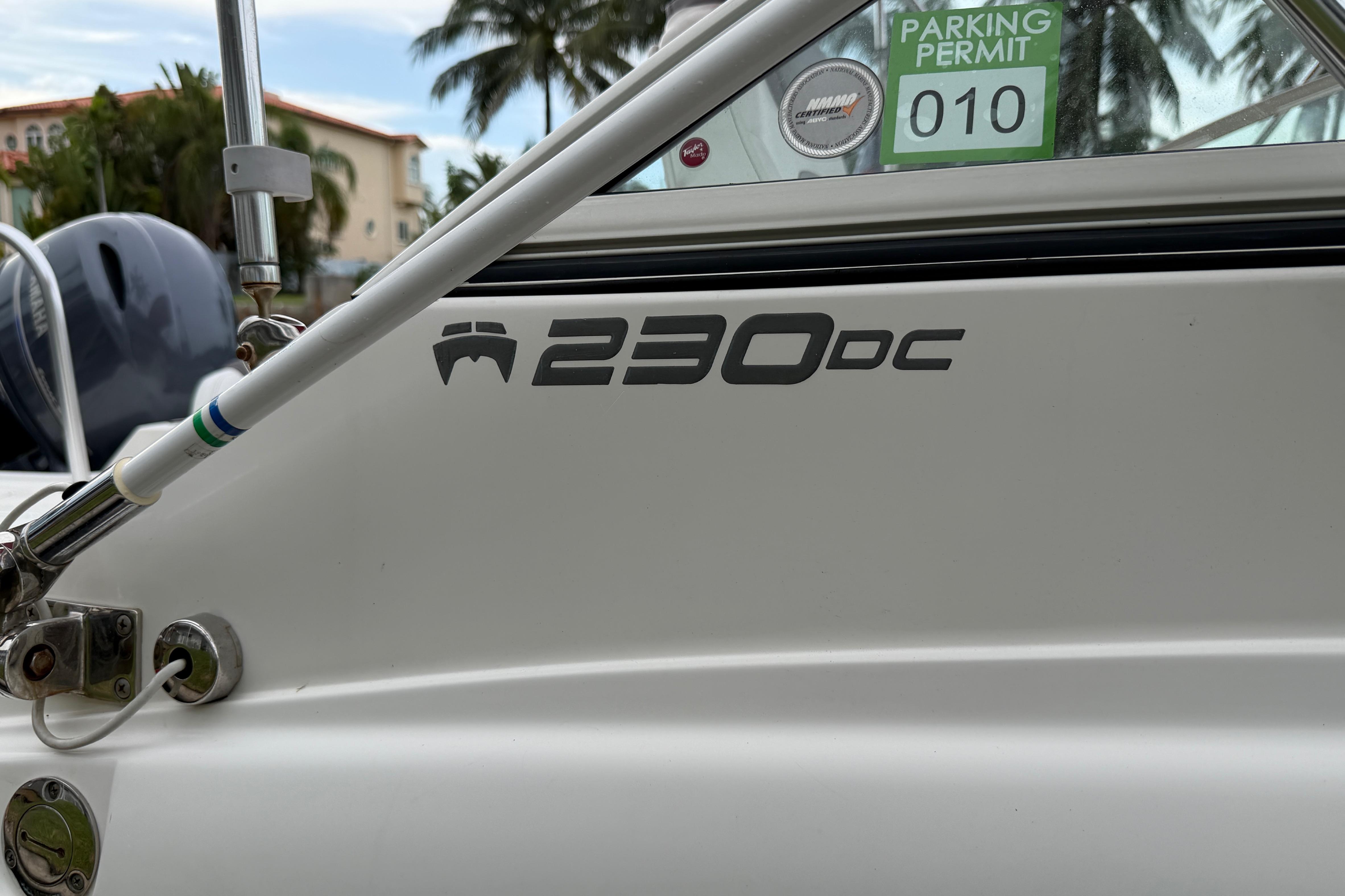 2019 World Cat 230 DC boat with parking permit sticker, palm trees in background.