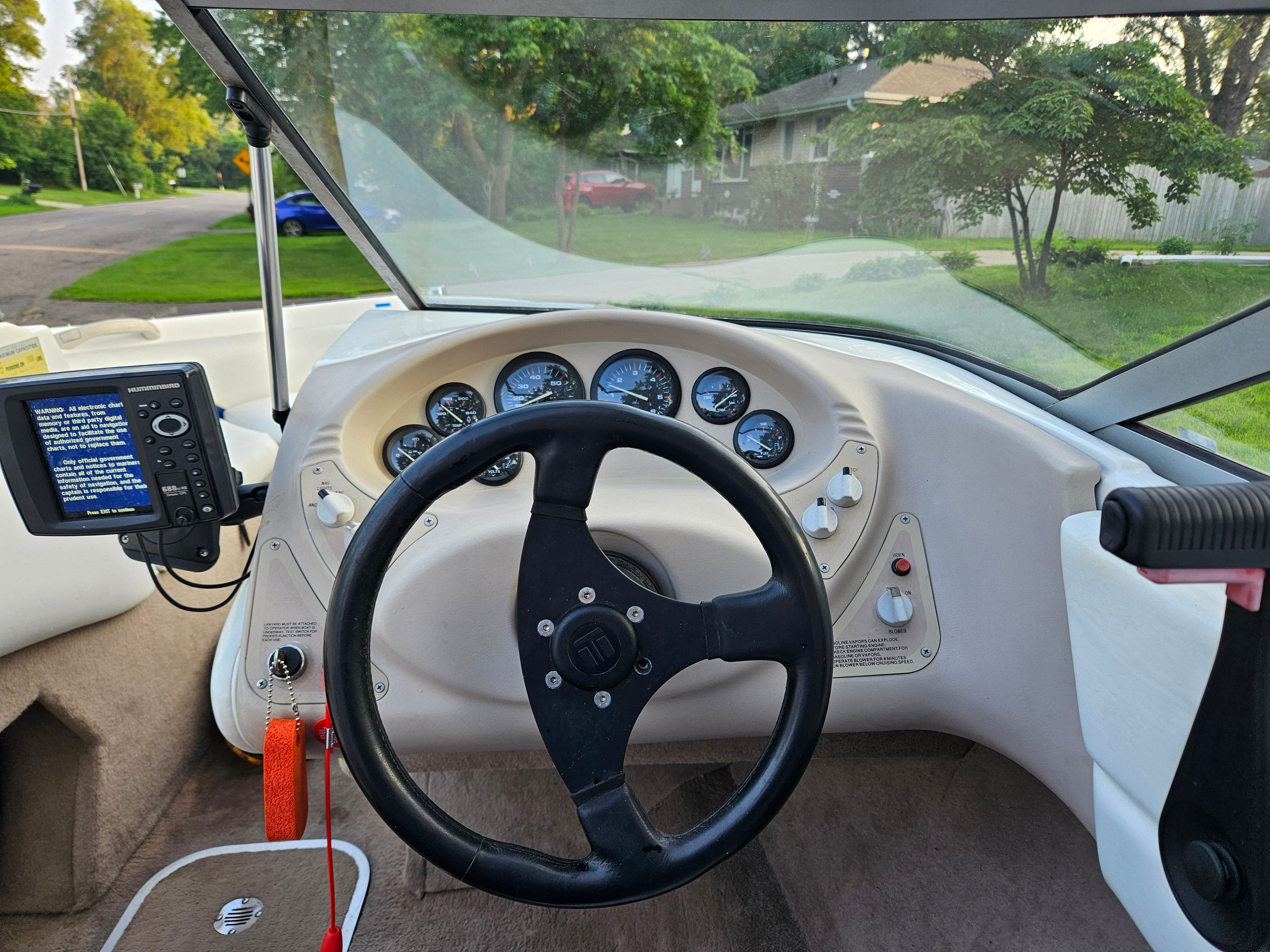 The image shows the cockpit of a 1996 Wellcraft Excel boat with a black steering wheel and gauges.