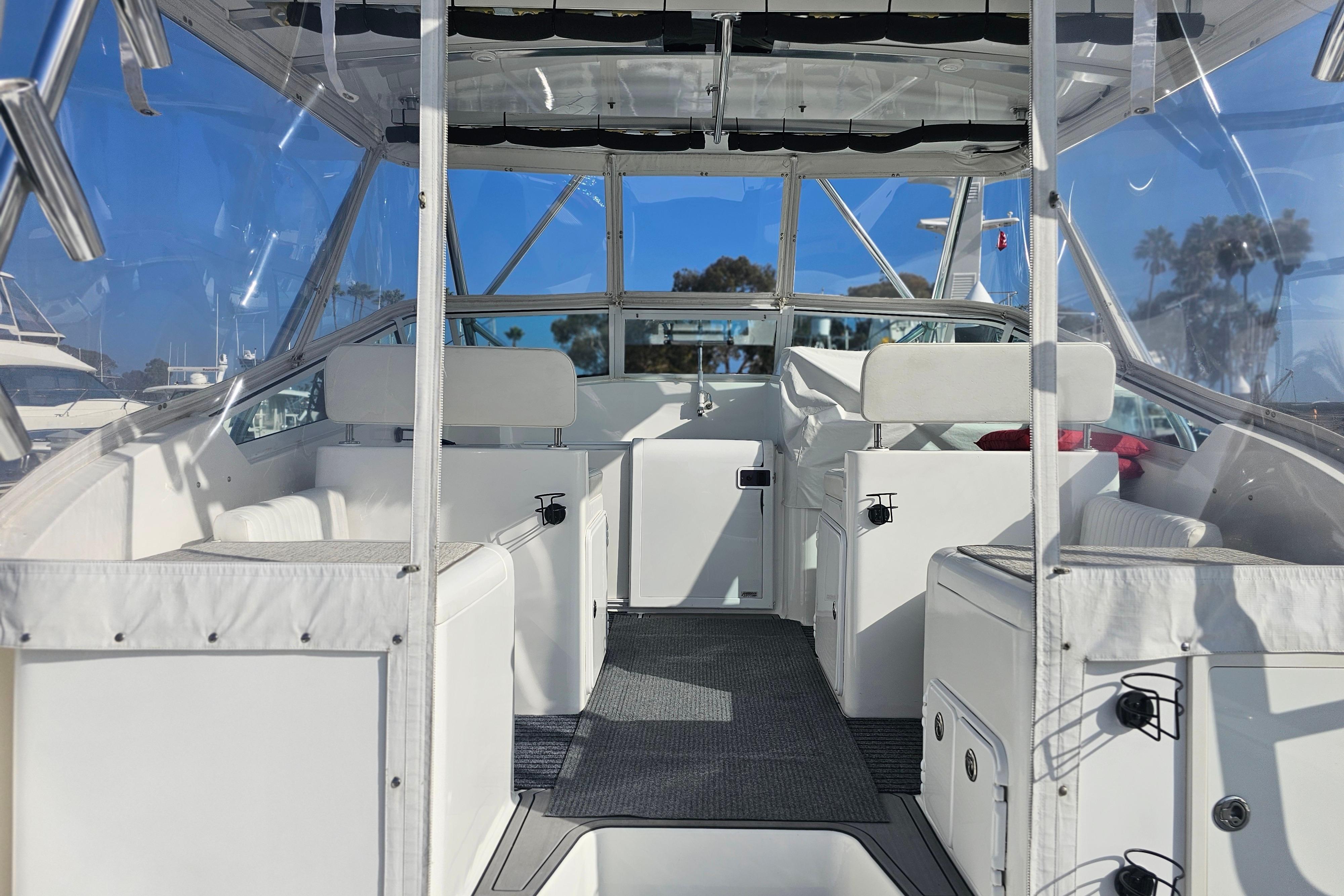 2003 Topaz 32 Express boat interior with white seating and clear canopy.