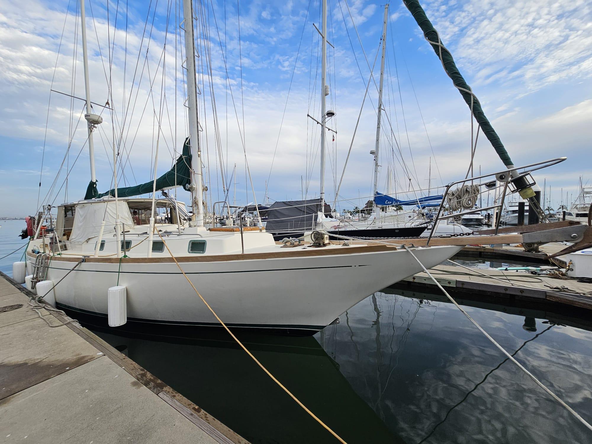 1978 Herreshoff 50 sailboat docked at marina under blue sky.