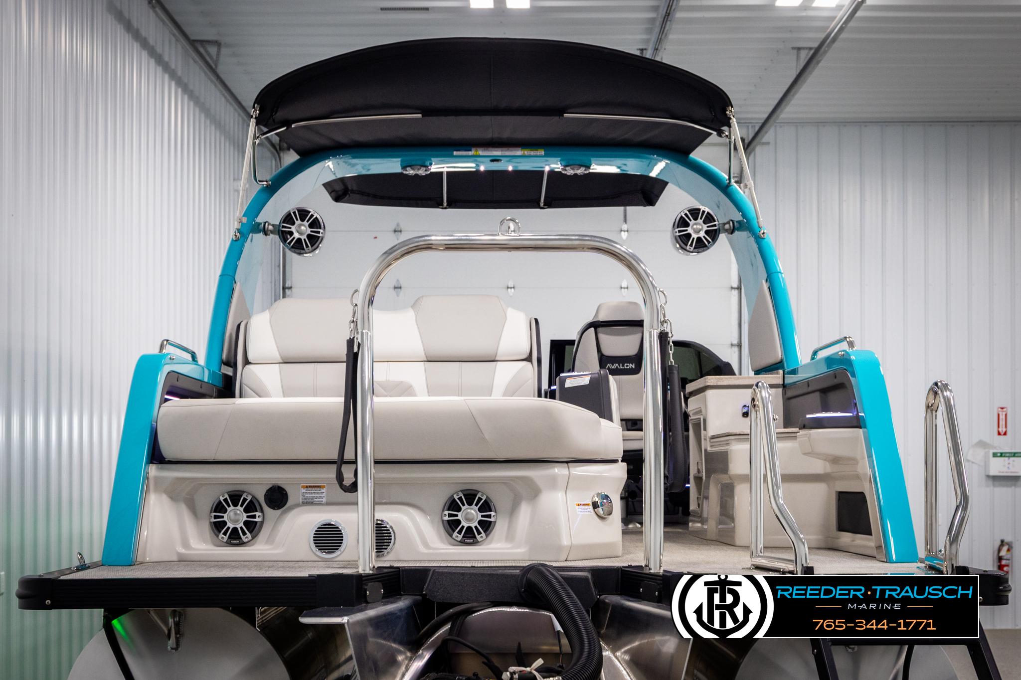 2025 Avalon 2585 Excal VRBW pontoon boat in showroom, featuring sleek design and modern seating.