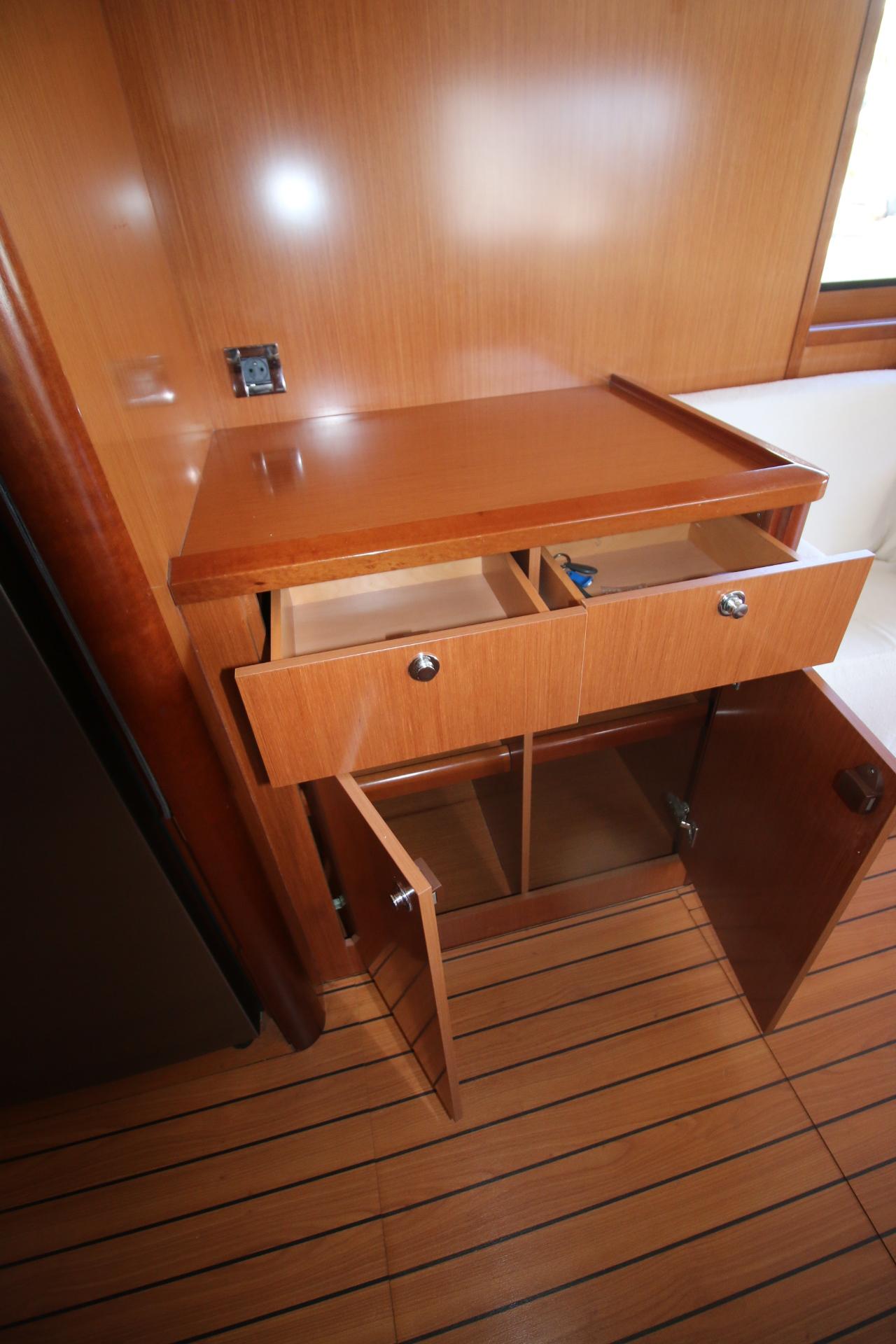 2008 Beneteau Swift Trawler 52 interior with open wooden drawers and cabinets.