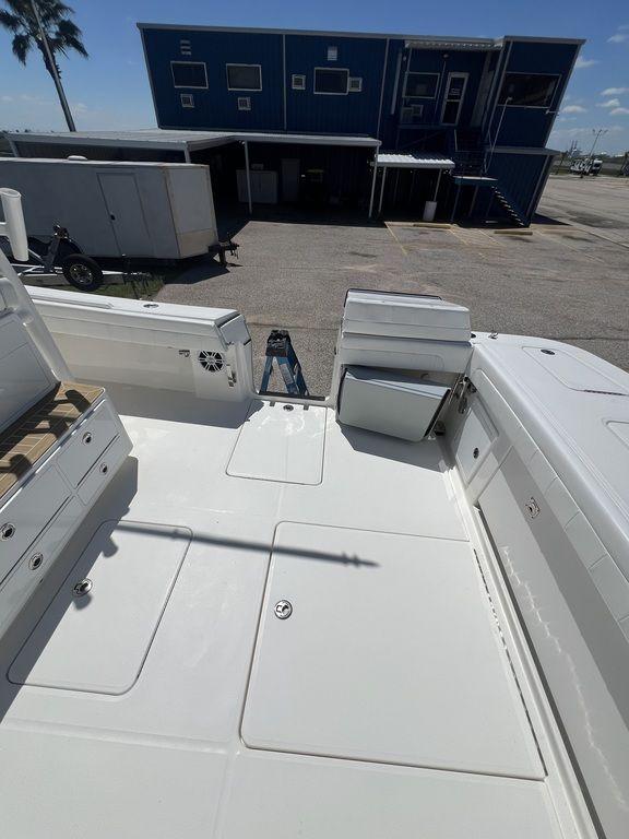 2021 Regulator 41 boat deck with storage compartments and seating, docked near a blue building.