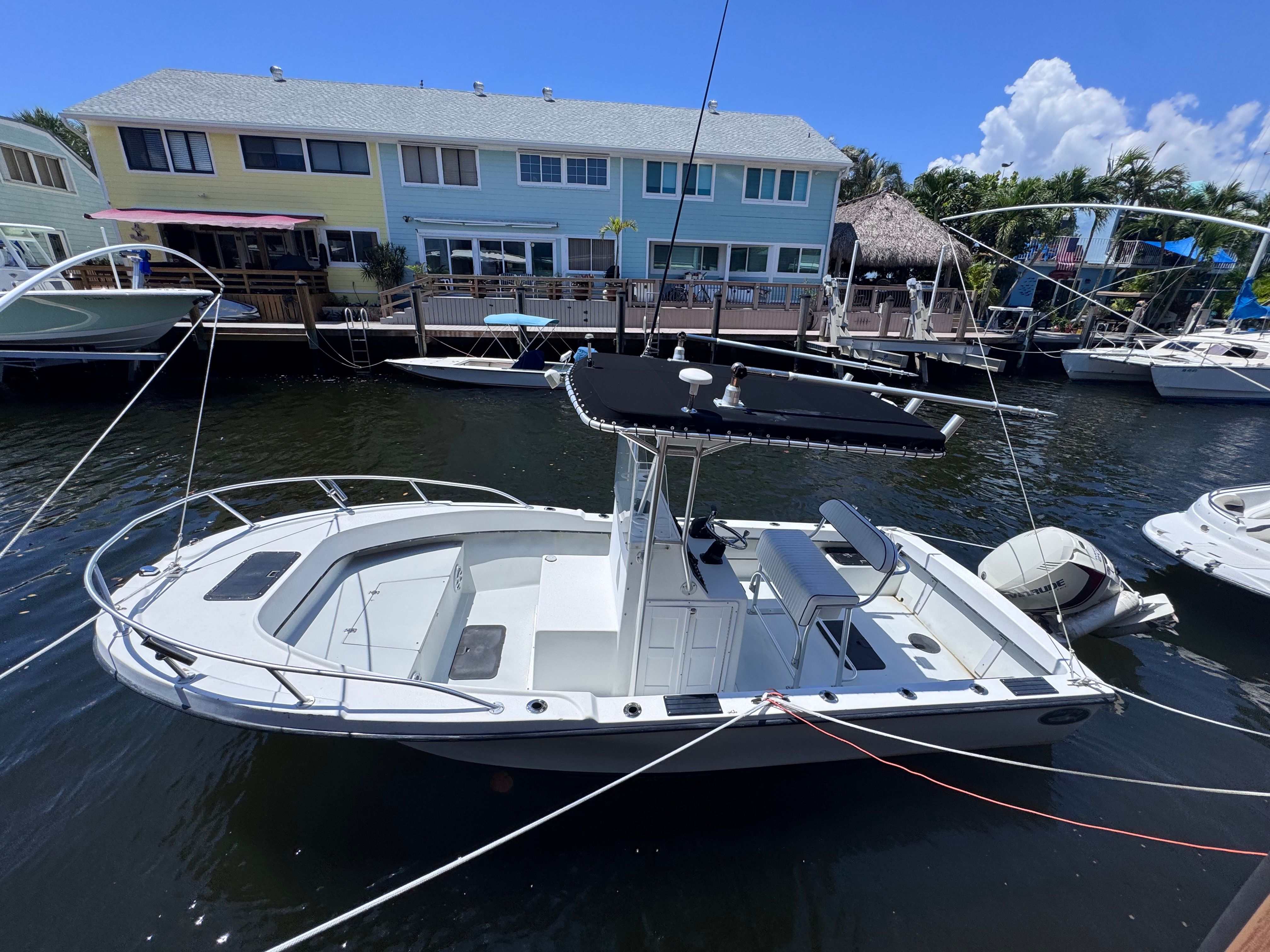 1998 Dusky 20.3 boat docked in front of colorful houses.