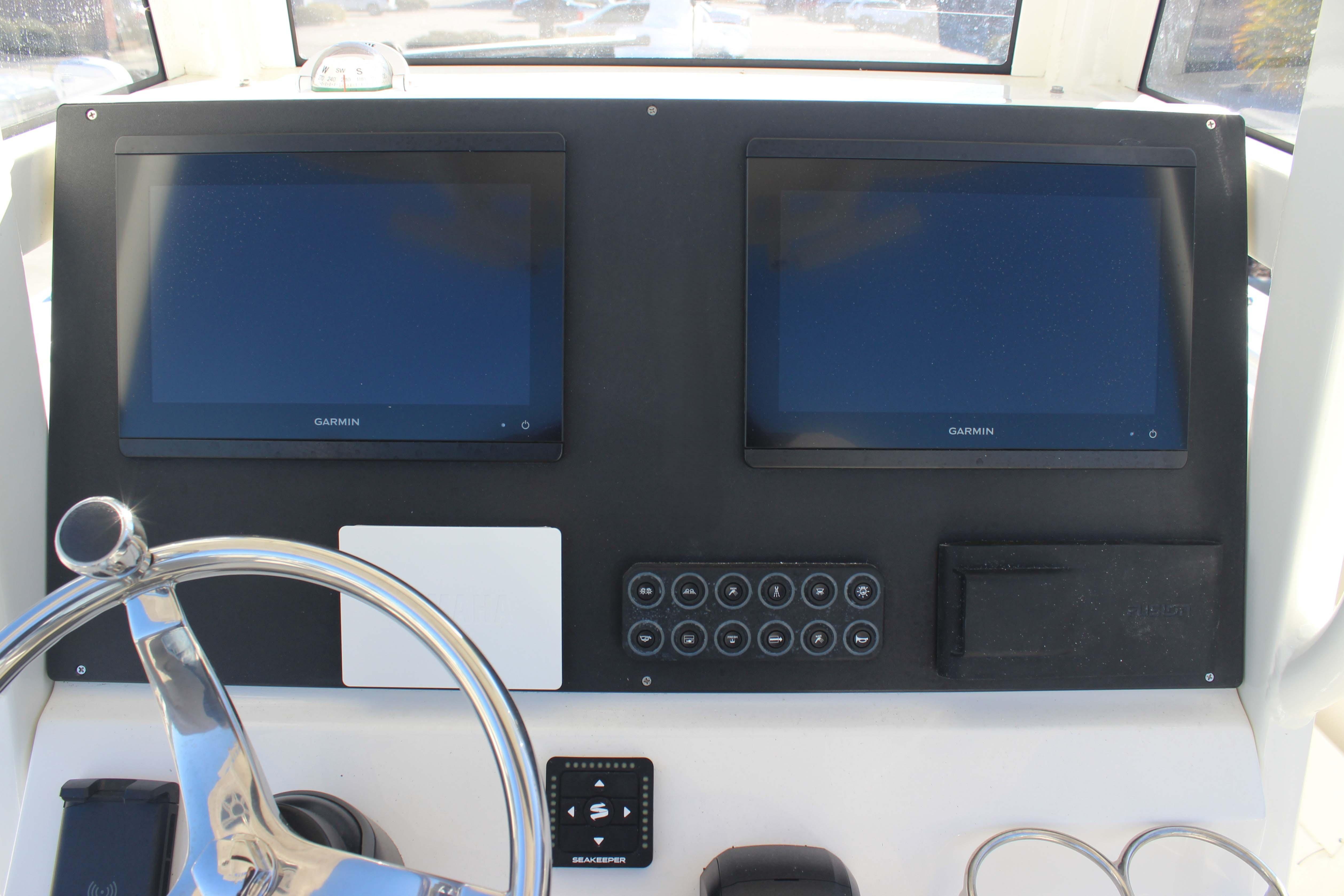 2025 Key West 239 FSR boat dashboard with dual Garmin displays and steering wheel.