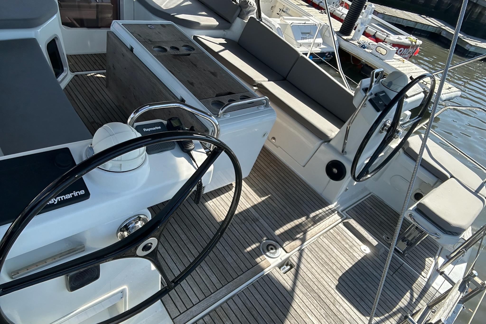 Cockpit of 2018 Jeanneau 51 yacht with dual steering wheels and seating area.