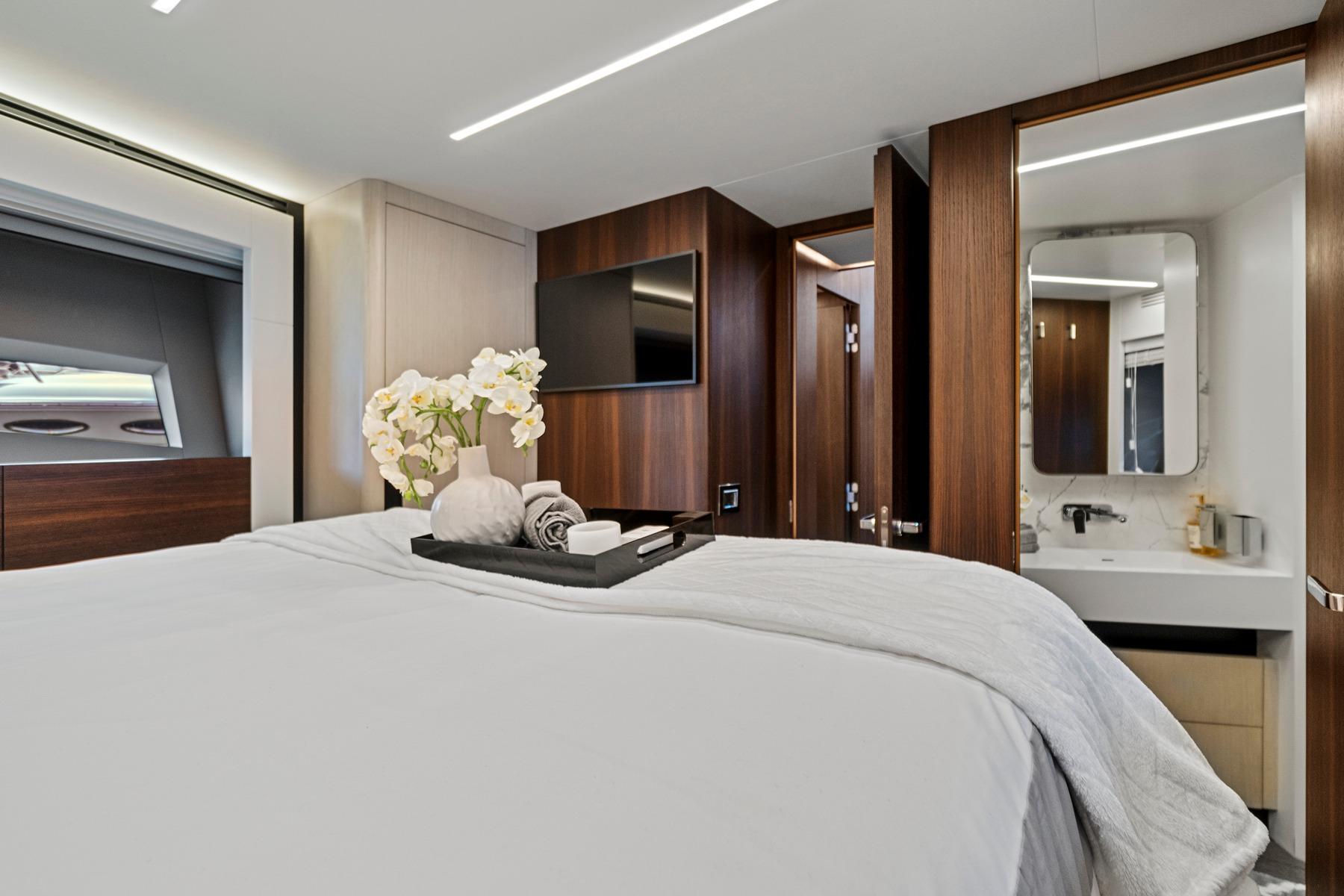 Luxurious bedroom in 2023 Astondoa 66 Flybridge yacht with elegant decor and modern amenities.