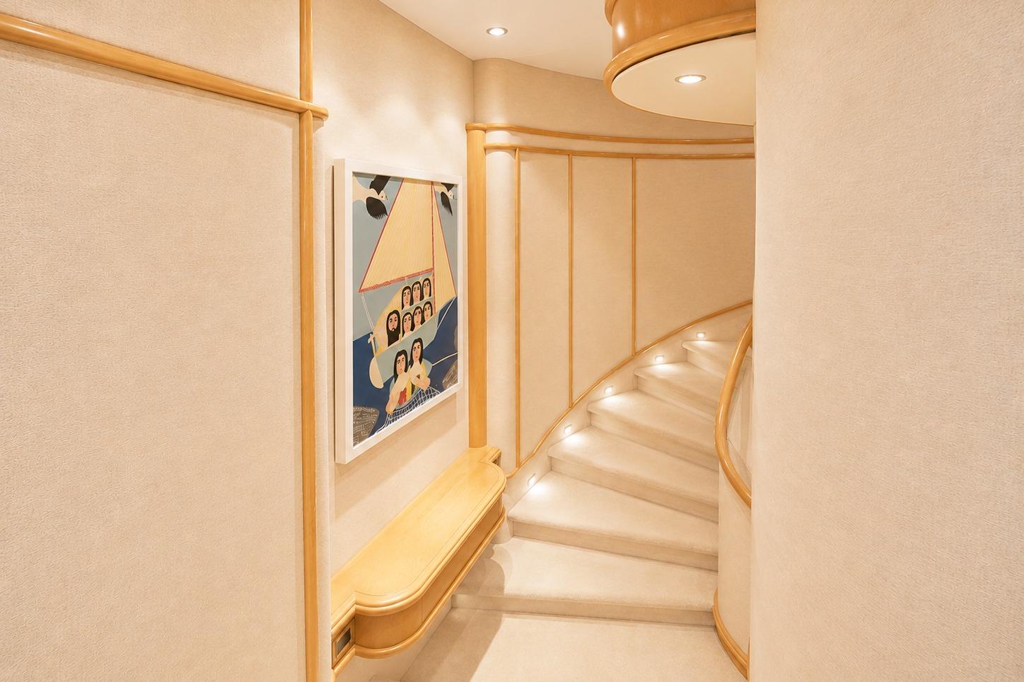 Luxurious yacht interior with curved staircase, artwork, and soft lighting, Crescent Custom Yachts 2000.