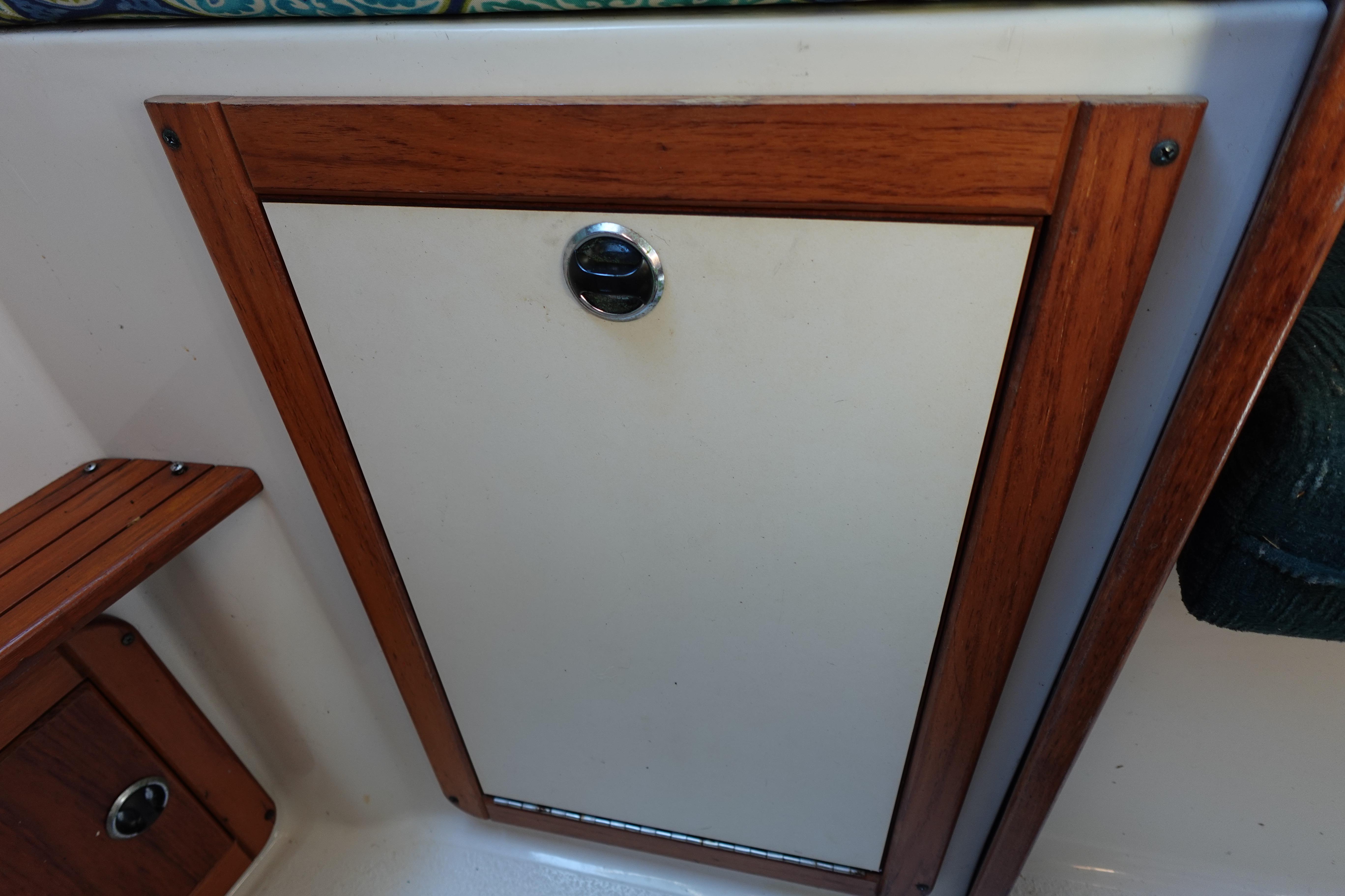 Wood-trimmed cabinet door on a 1997 Catalina 28 sailboat interior.